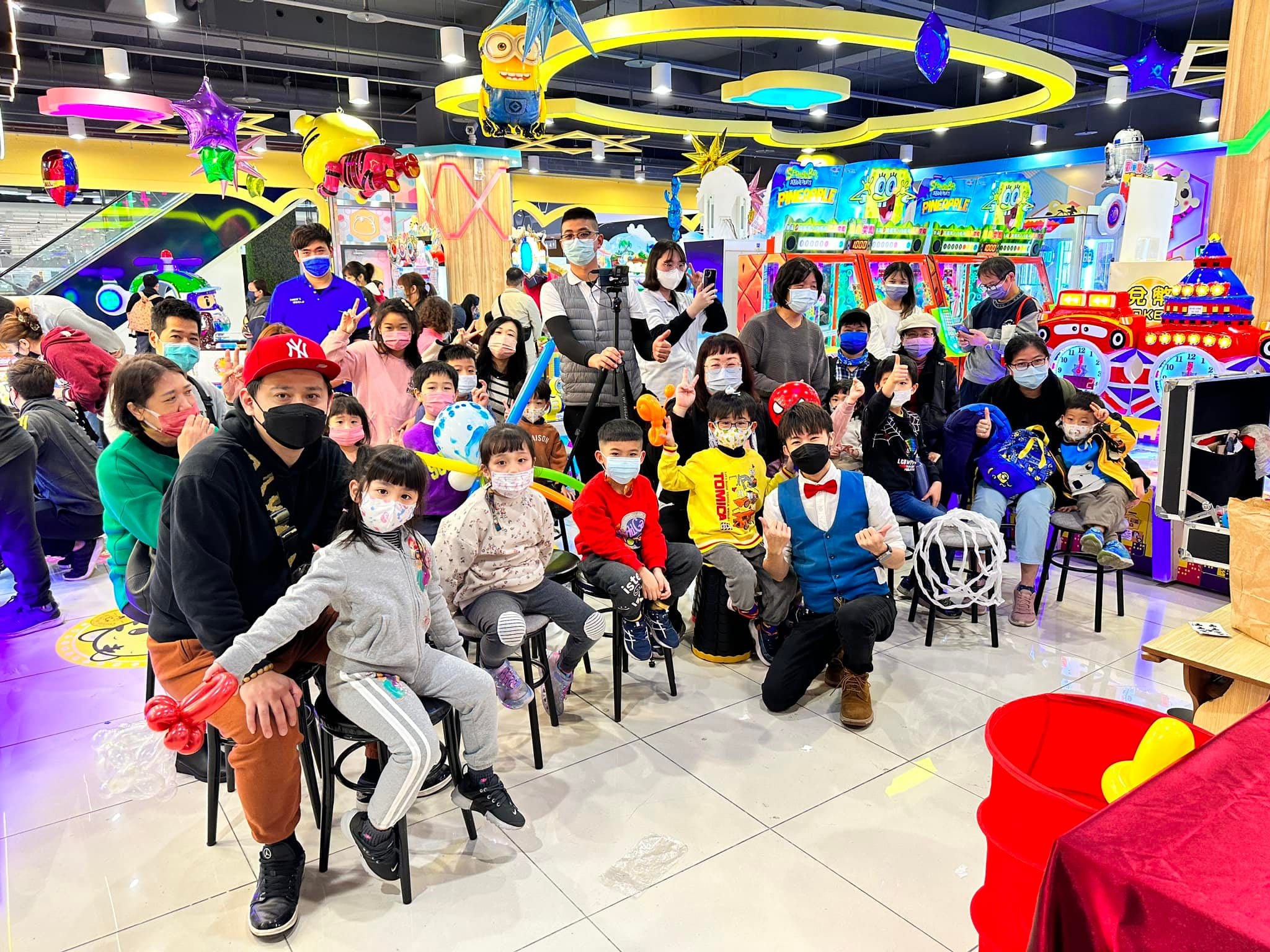 老虎歡樂世界遊戲場內，孩子與家長圍坐，和柯男一起大合照