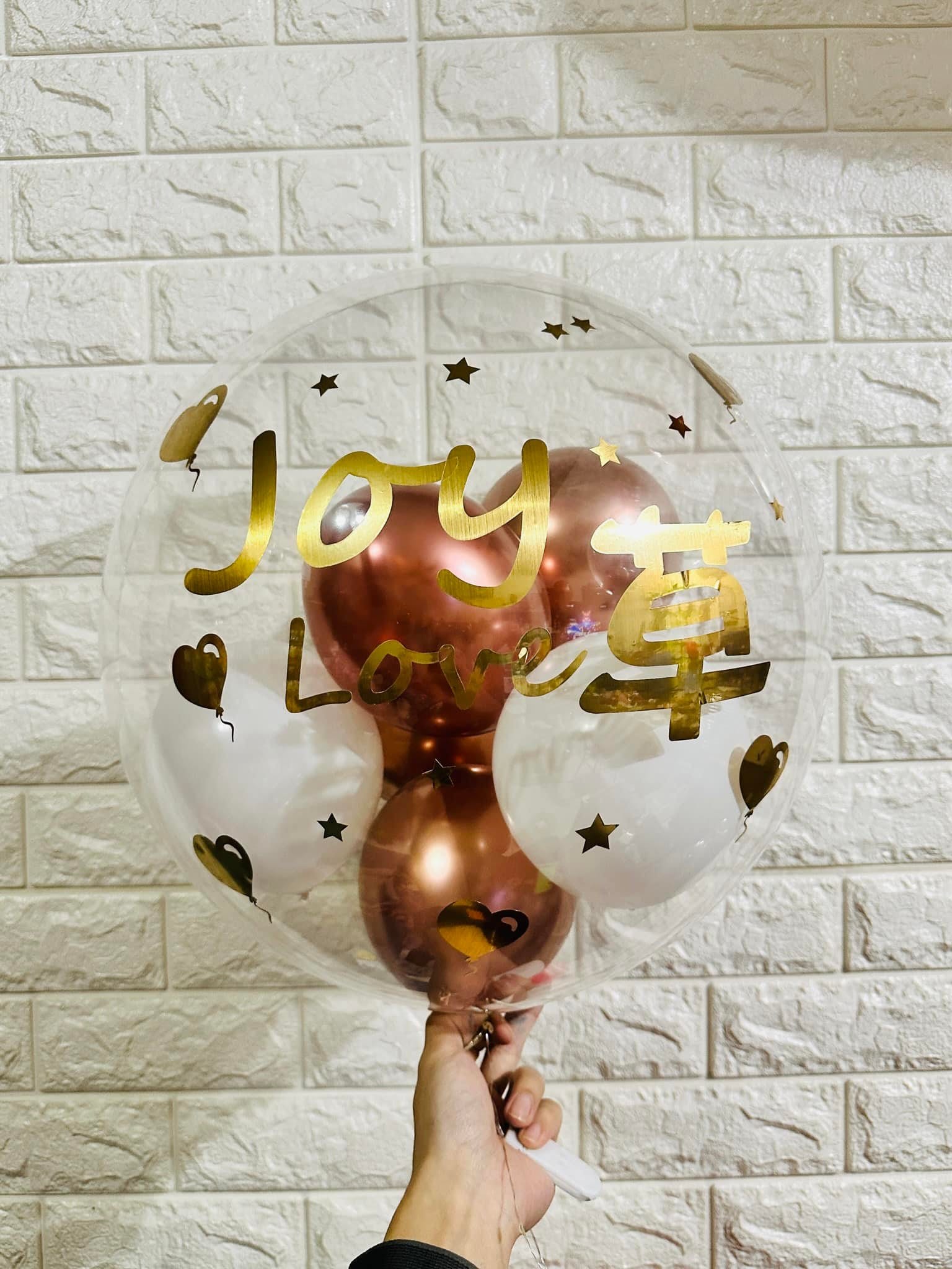 透明波波球內裝玫瑰金與白色氣球,球面貼著金色英文名與 Love 字樣