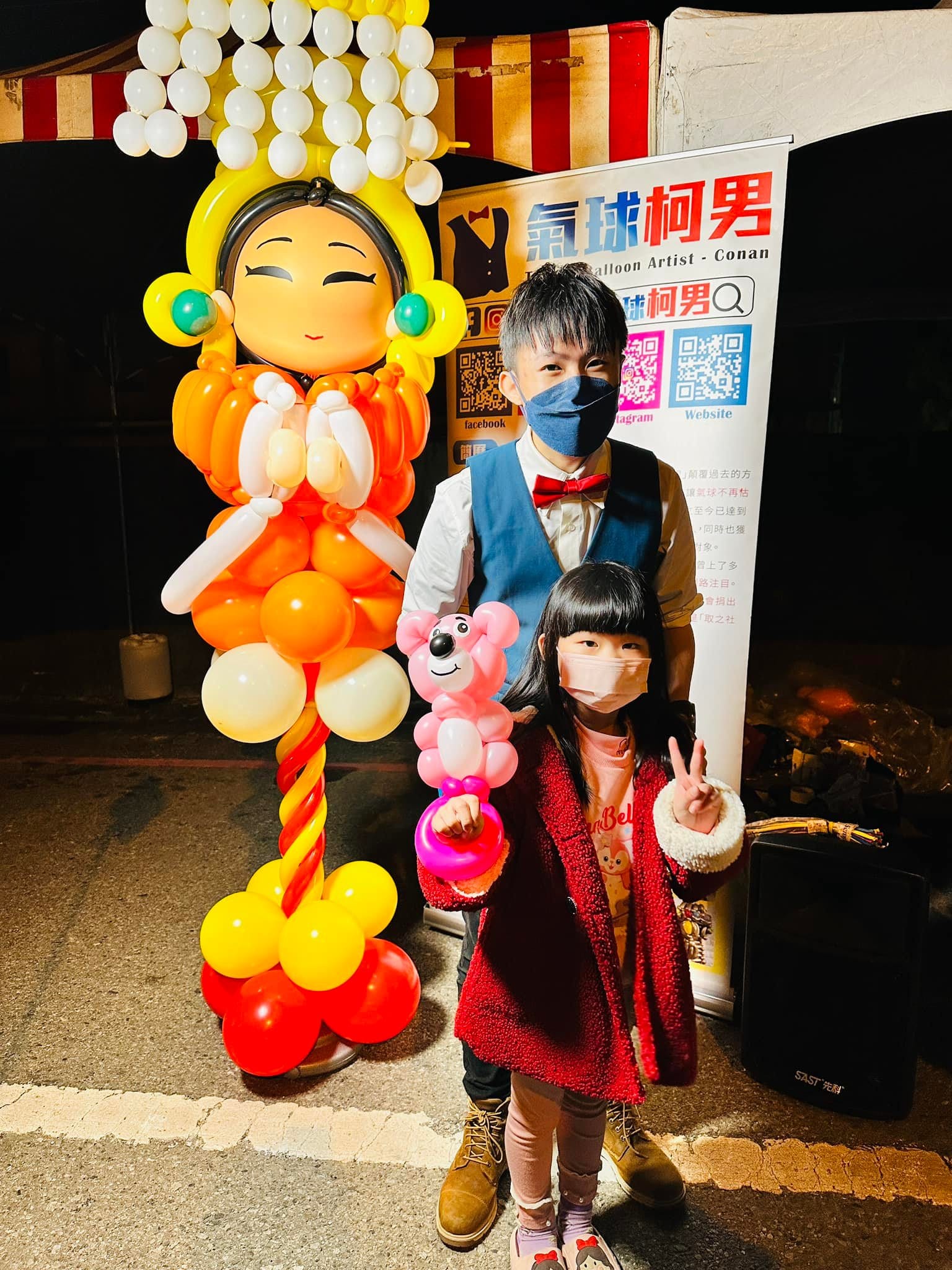 小女孩拿著粉紅小熊氣球，與柯男在媽祖氣球前合照