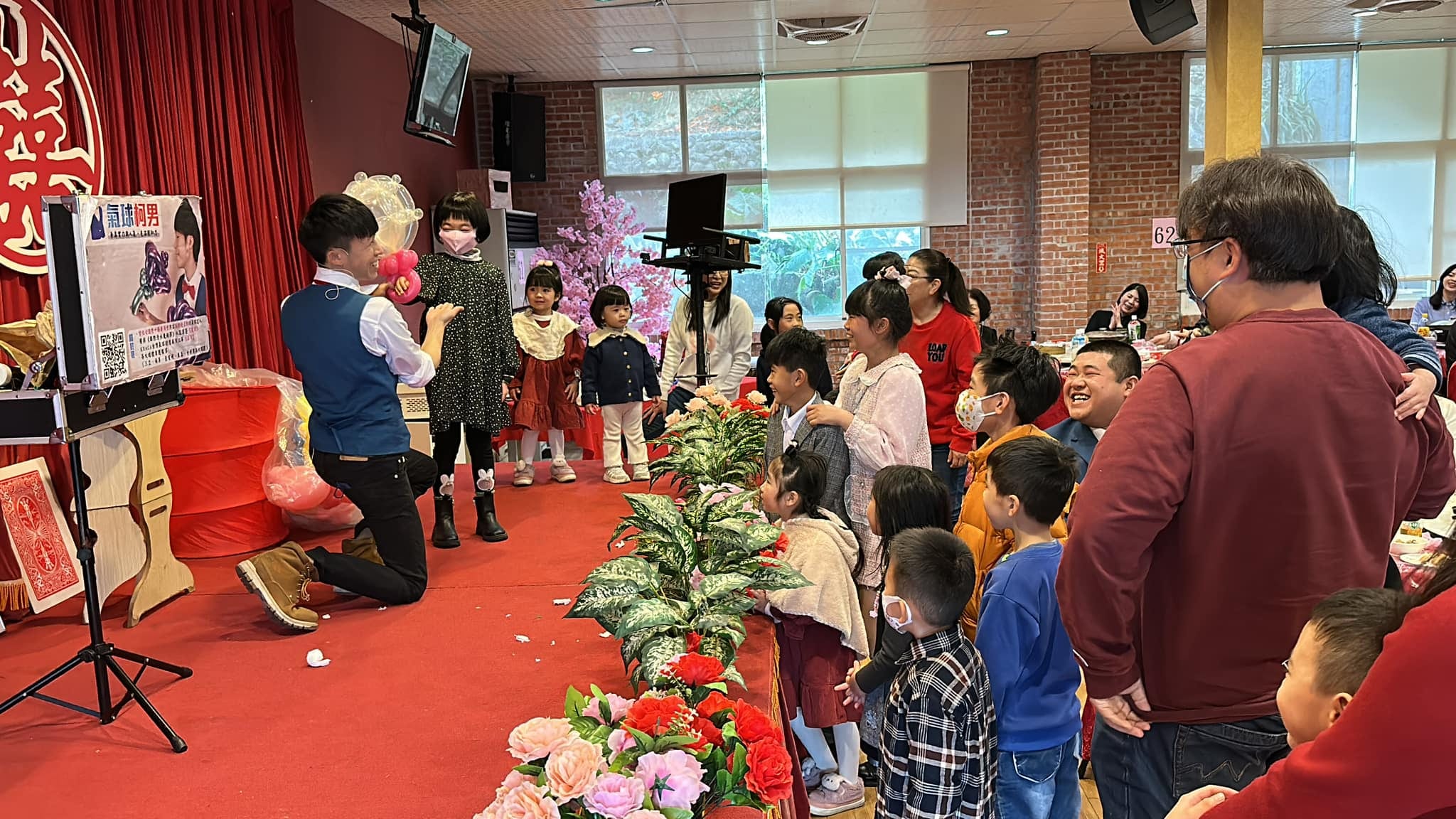 婚宴紅地毯旁，柯男蹲著和上台的小女孩互動，孩子們圍在一旁