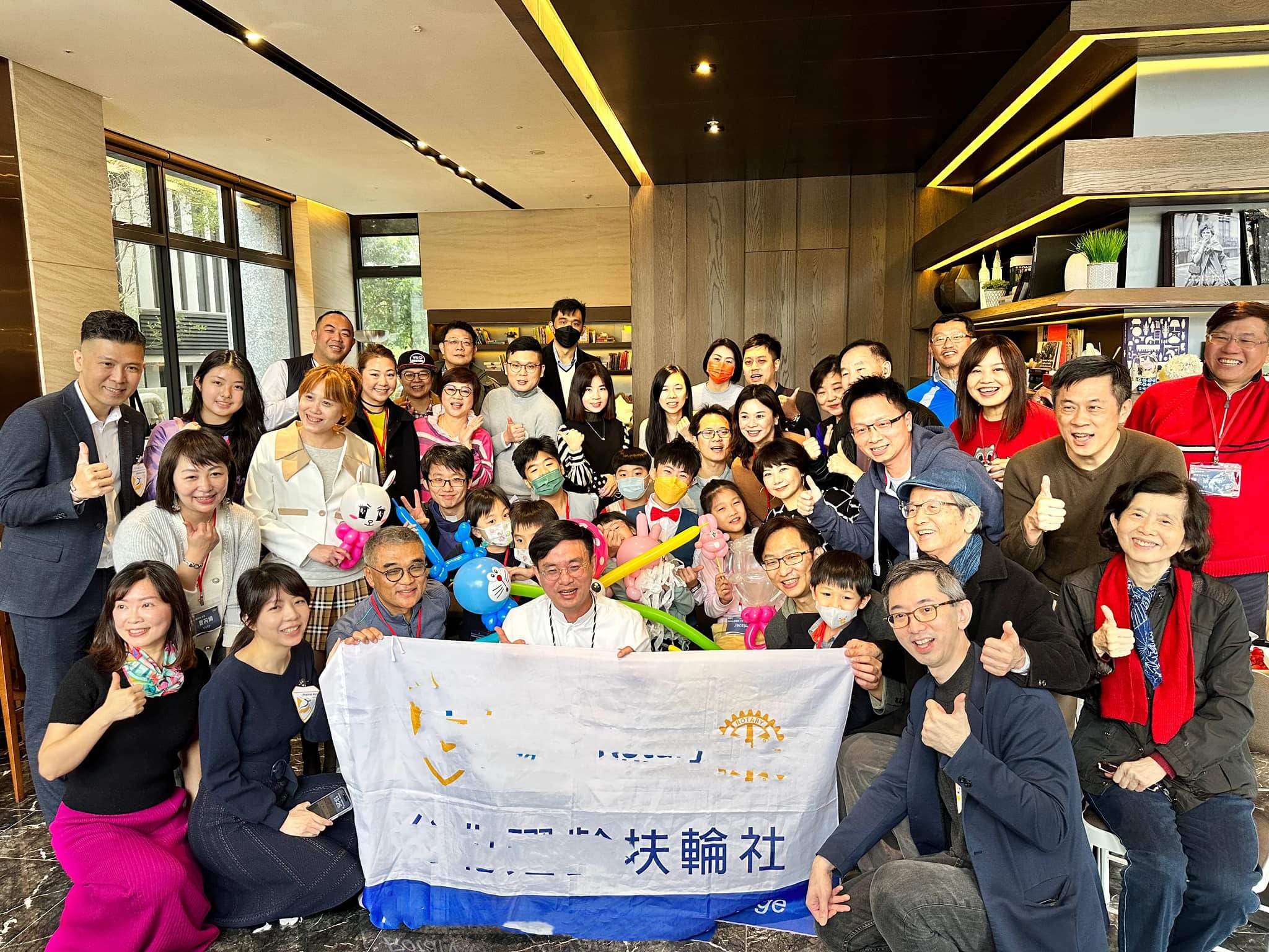 另一場扶輪社活動，大人小孩拿著造型氣球與社旗大合照