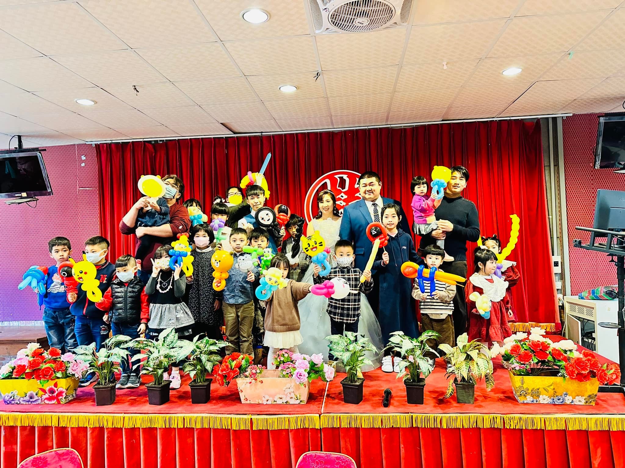 苗栗婚禮舞台上，新人與拿著造型氣球的孩子們和柯男大合照