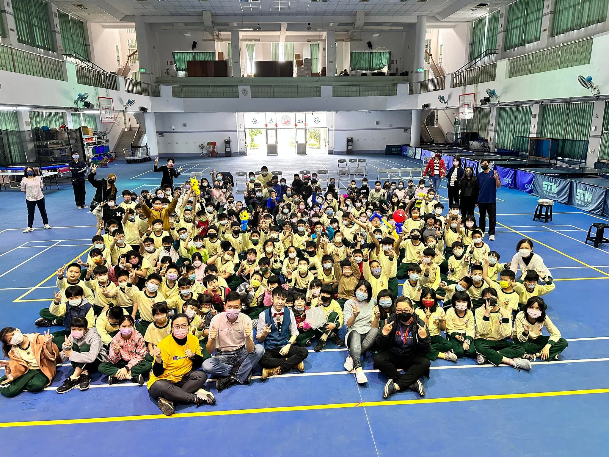 台中春安國小活動中心，穿黃色制服的學生們和柯男比讚大合照