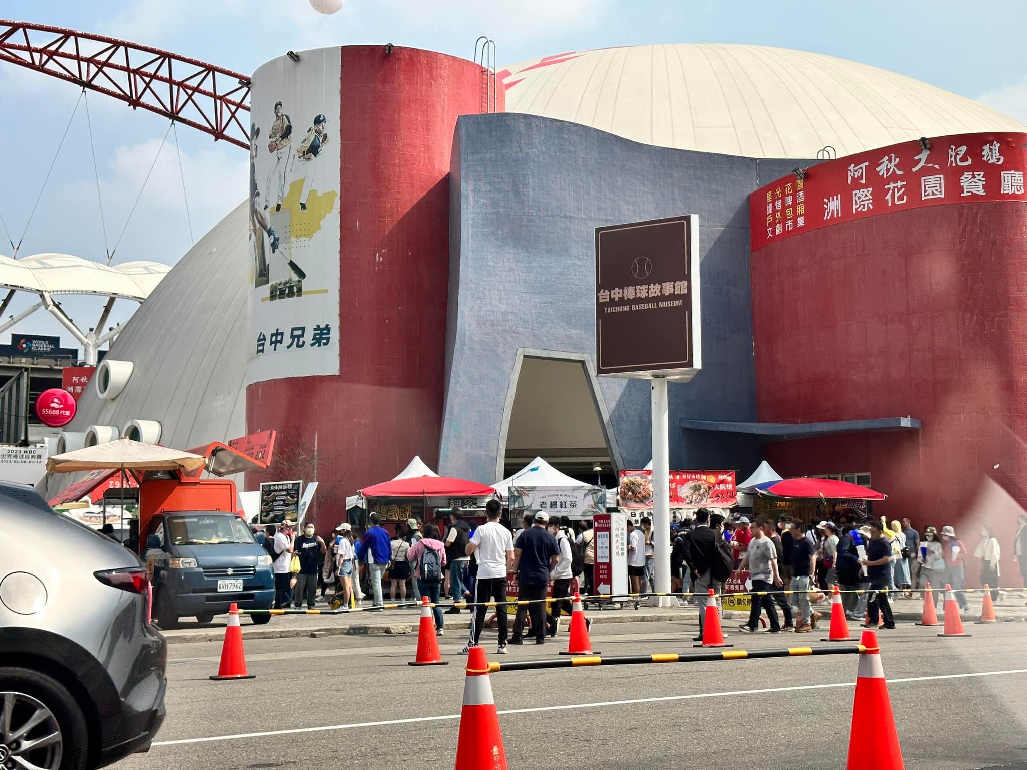 台中洲際棒球場外排隊的人潮與白色帳篷，紅色三角錐圍出動線
