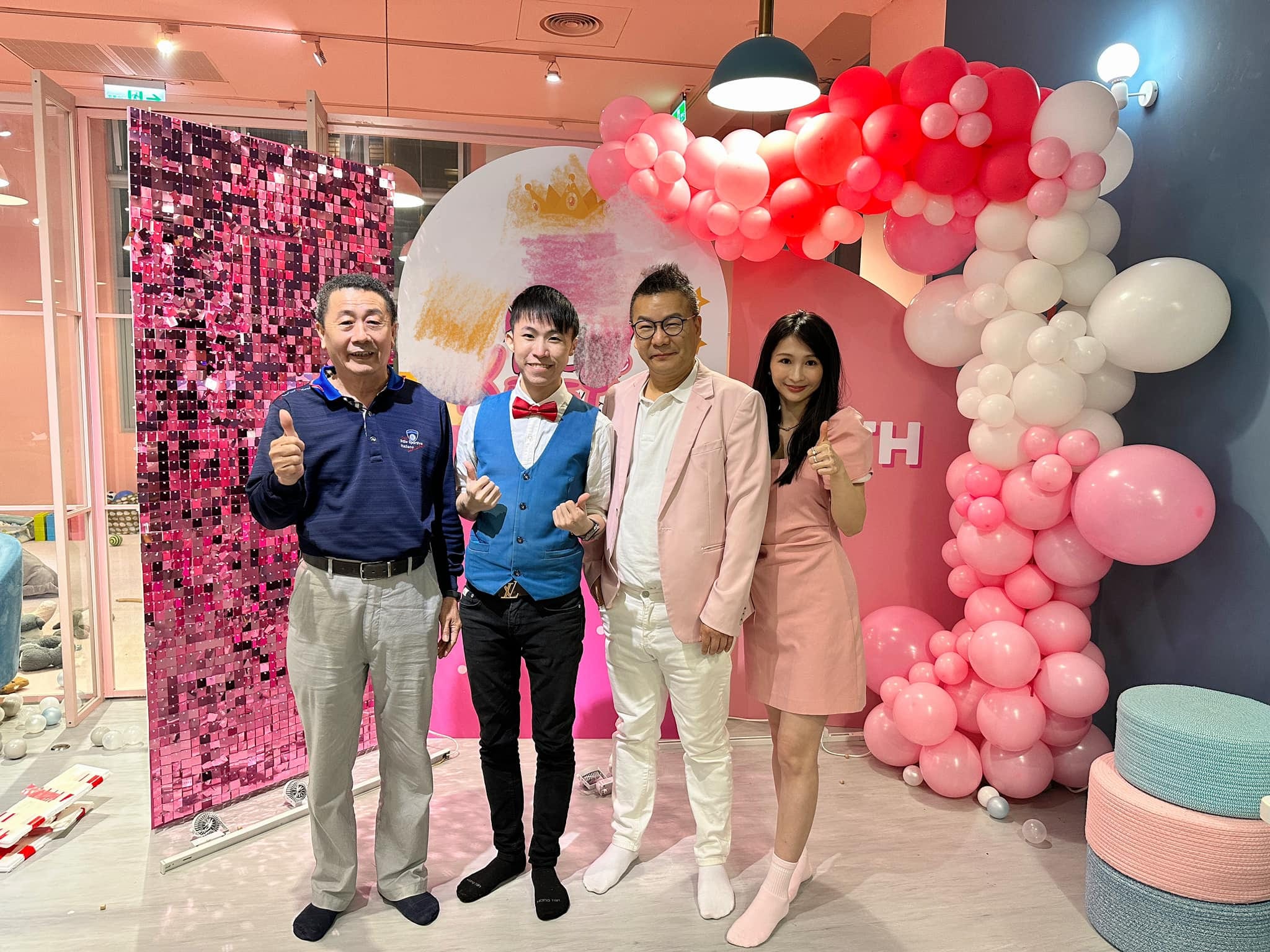 柯男與派對主人家在粉紅白氣球拱門與亮片牆前合照