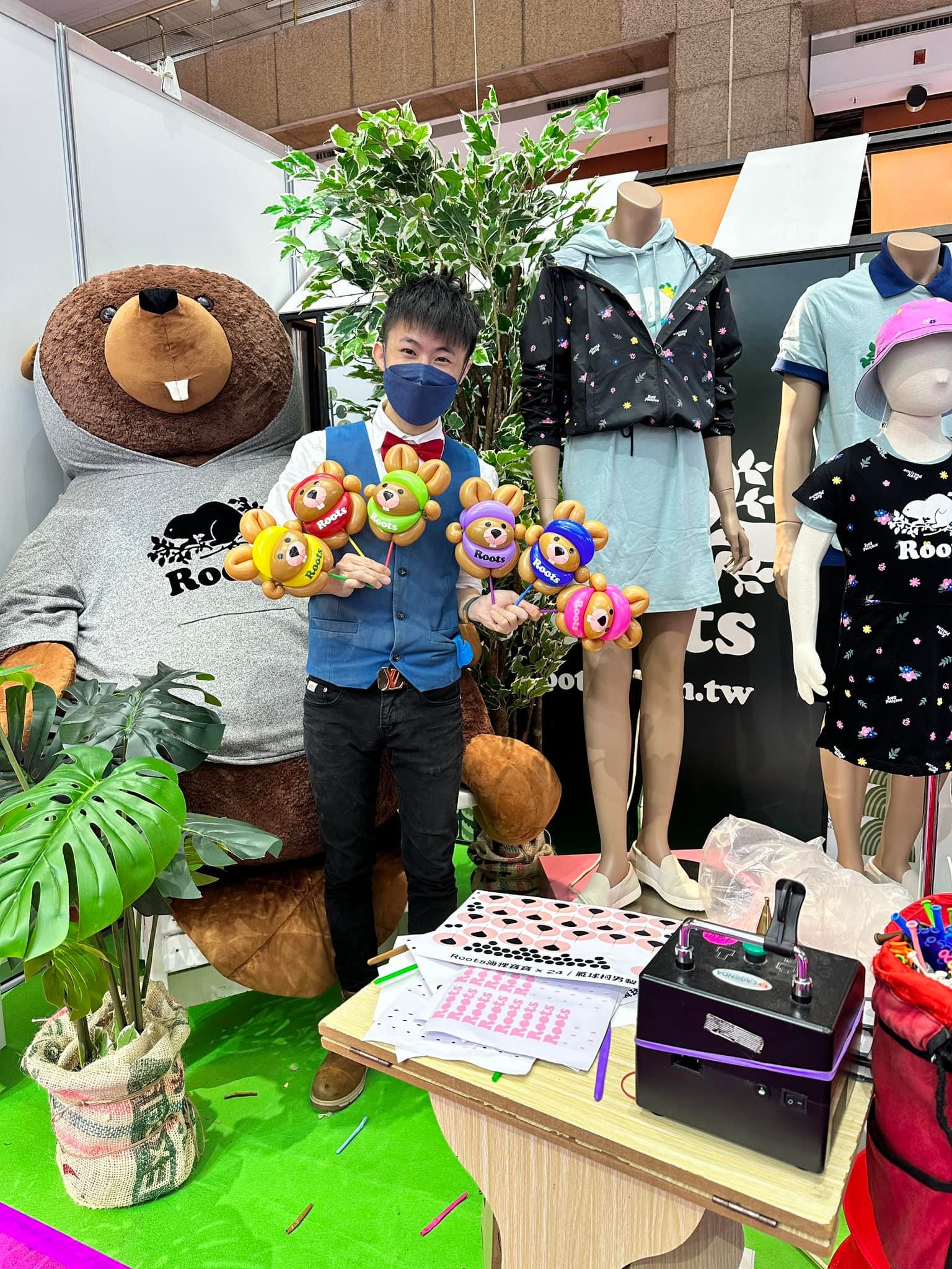 台北世貿婦幼展 Roots 攤位，柯男手拿六色海狸寶寶造型氣球