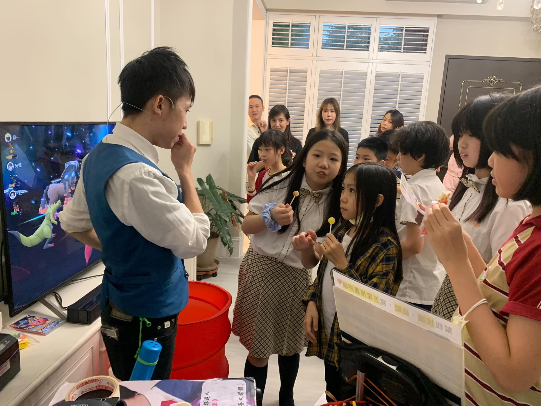 孩子們圍在柯男身旁，專心看他手上的魔術