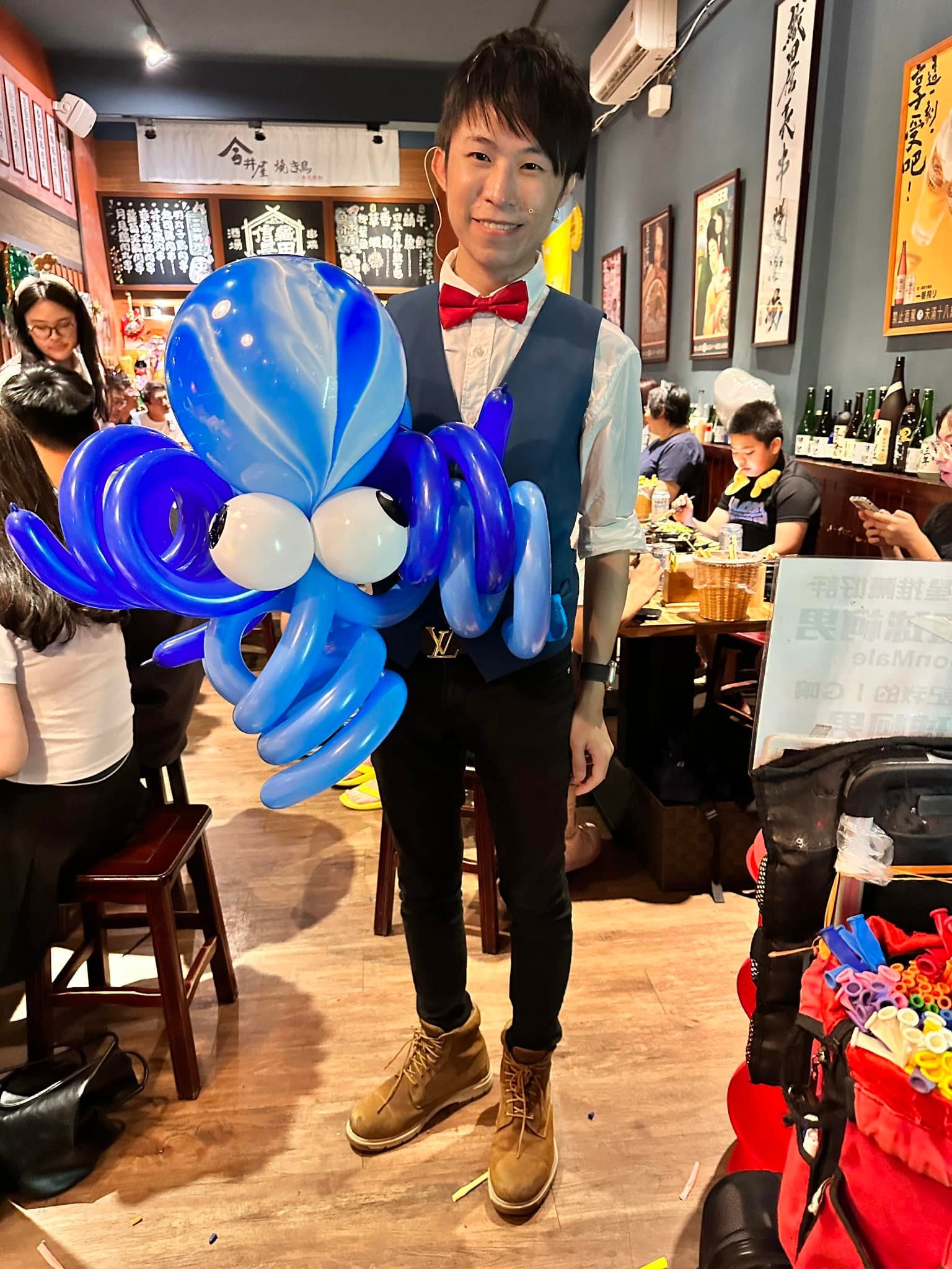 柯男在餐廳裡抱著藍色大章魚造型氣球