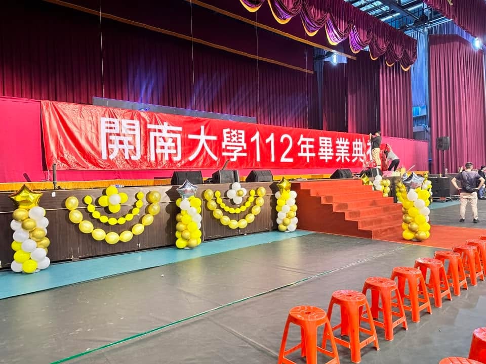 舞台前方的黃金色氣球弧形串，兩側立著氣球柱