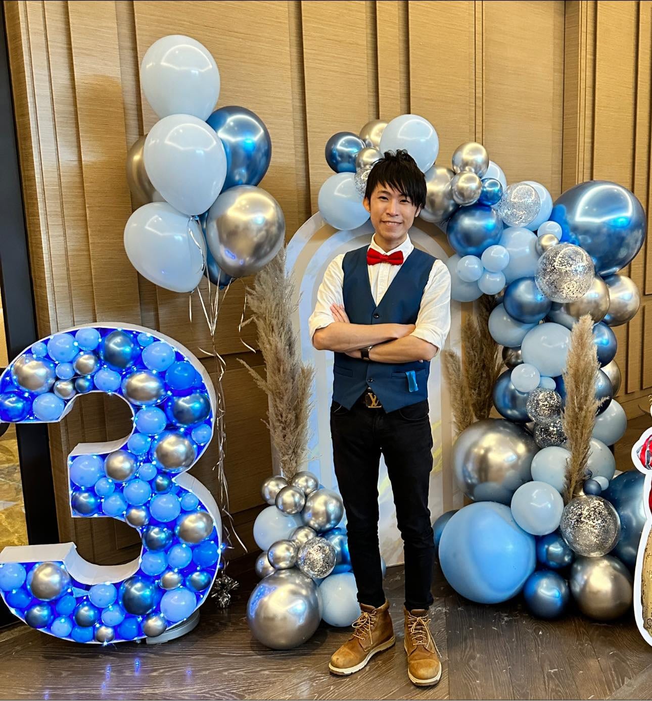 2023 年 6 月宴會廳，柯男站在藍銀色氣球拱門與數字 3 氣球框前