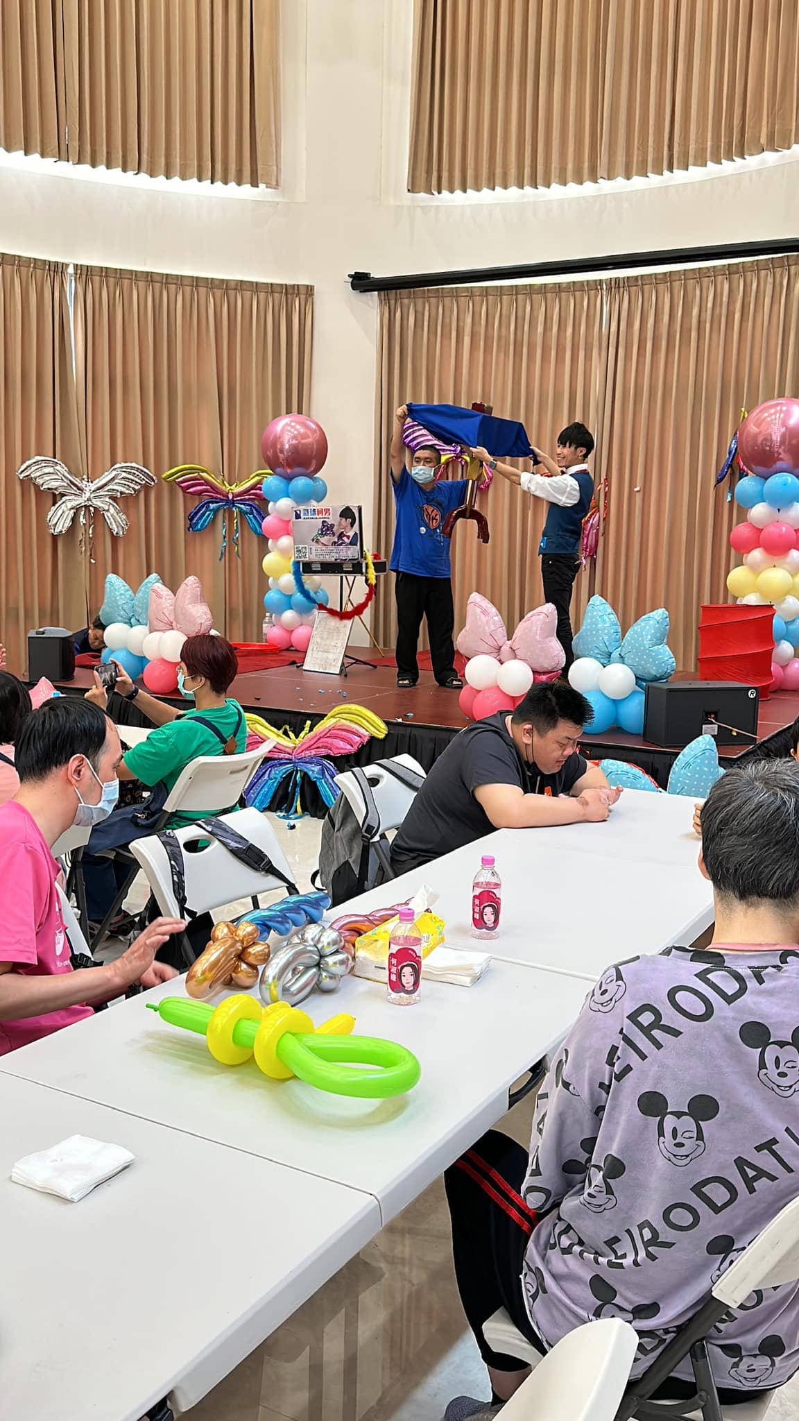 新北三重唐氏症公益演出，柯男和上台的學員一起拉開藍色魔術布