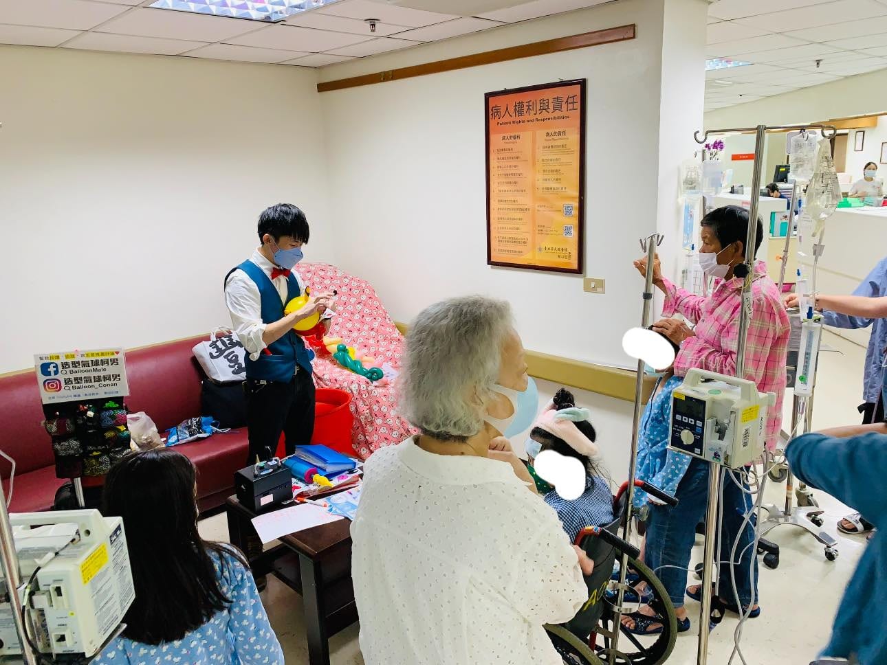 兒童病房走廊旁的交誼區，家屬與病童圍著柯男看氣球表演