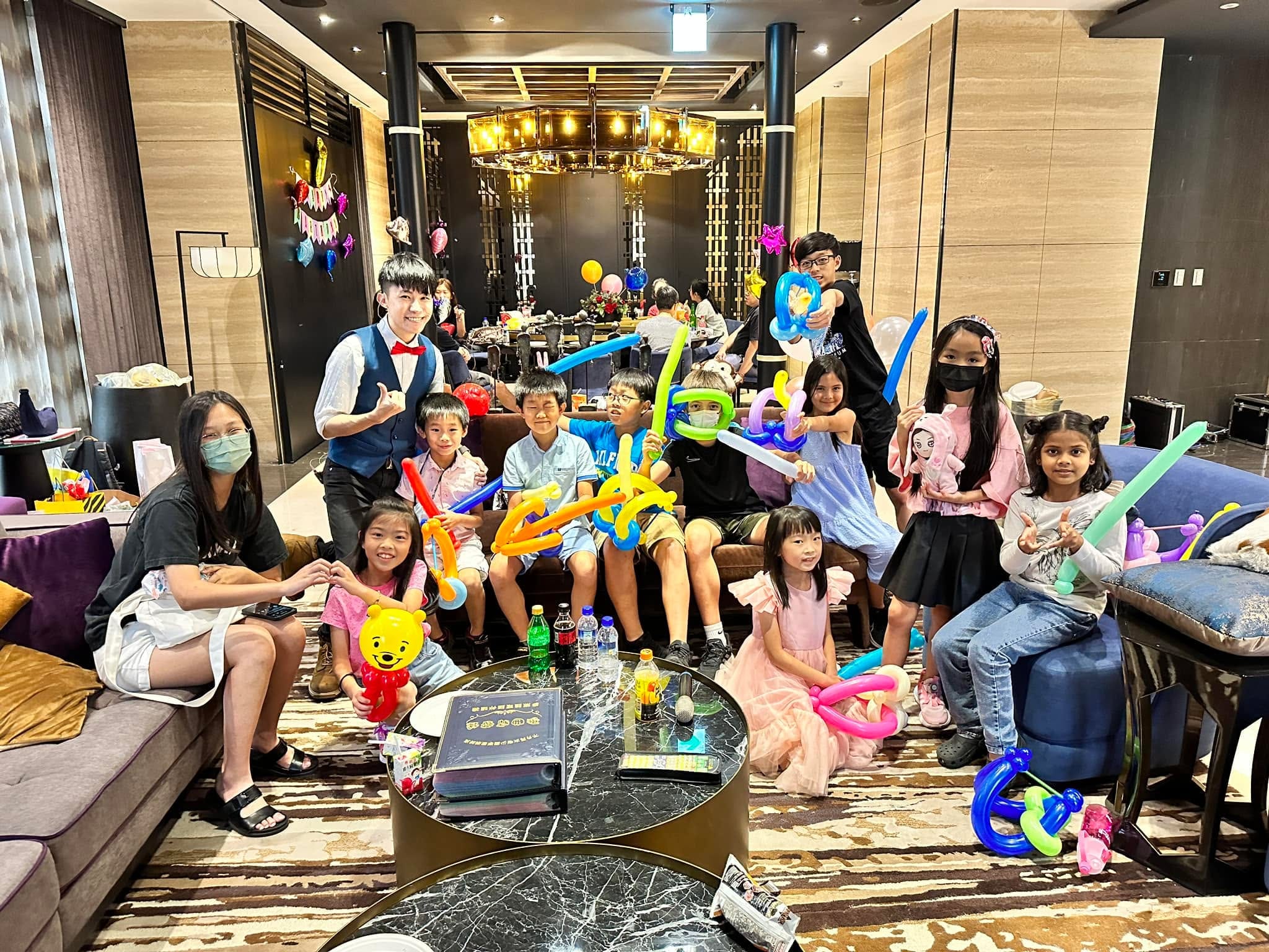2023 年 6 月包廂派對，孩子們在沙發區拿著弓箭與寶劍氣球和柯男合照