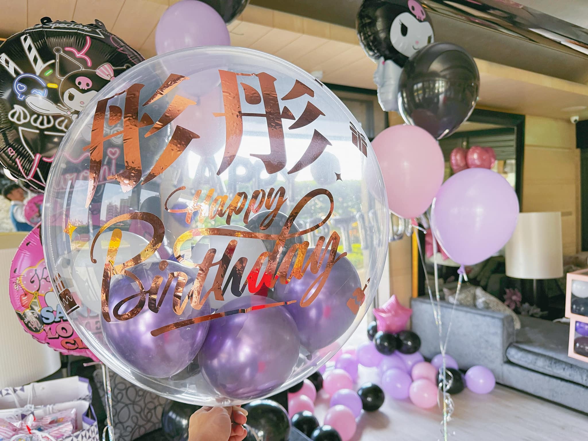 透明波波球上寫著玫瑰金字「彤彤 Happy Birthday」，裡面裝紫色小氣球，背景是庫洛米鋁箔氣球和黑粉紫氣球