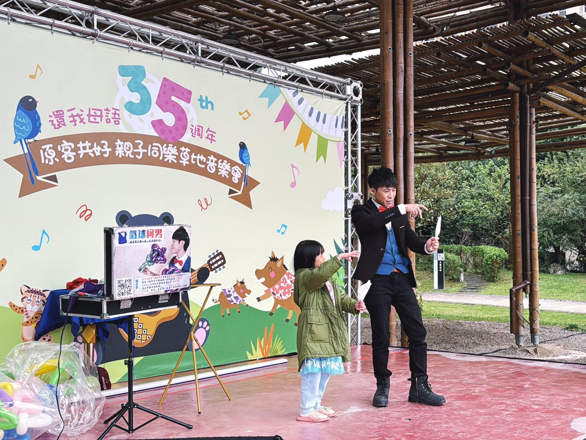 親子草地音樂會舞台上，柯男和上台小女孩一起變魔術