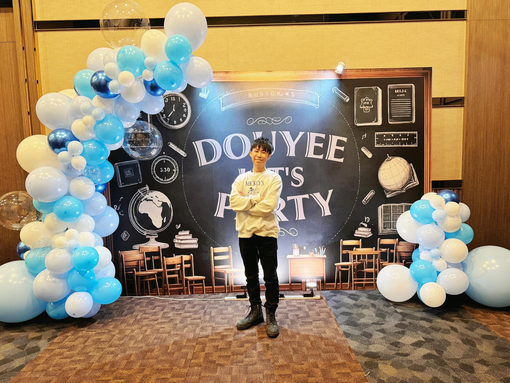 台中尾牙黑板插畫風派對背板，左側藍白氣球串，柯男站在中央