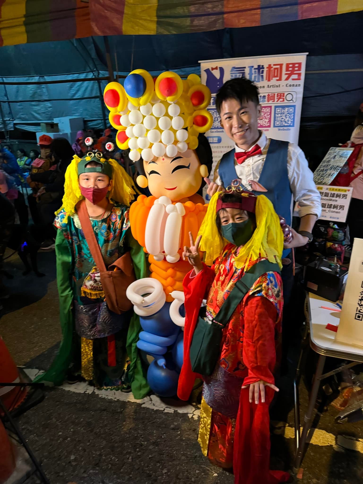 穿戴神明裝扮的香客和柯男一起與氣球媽祖合影