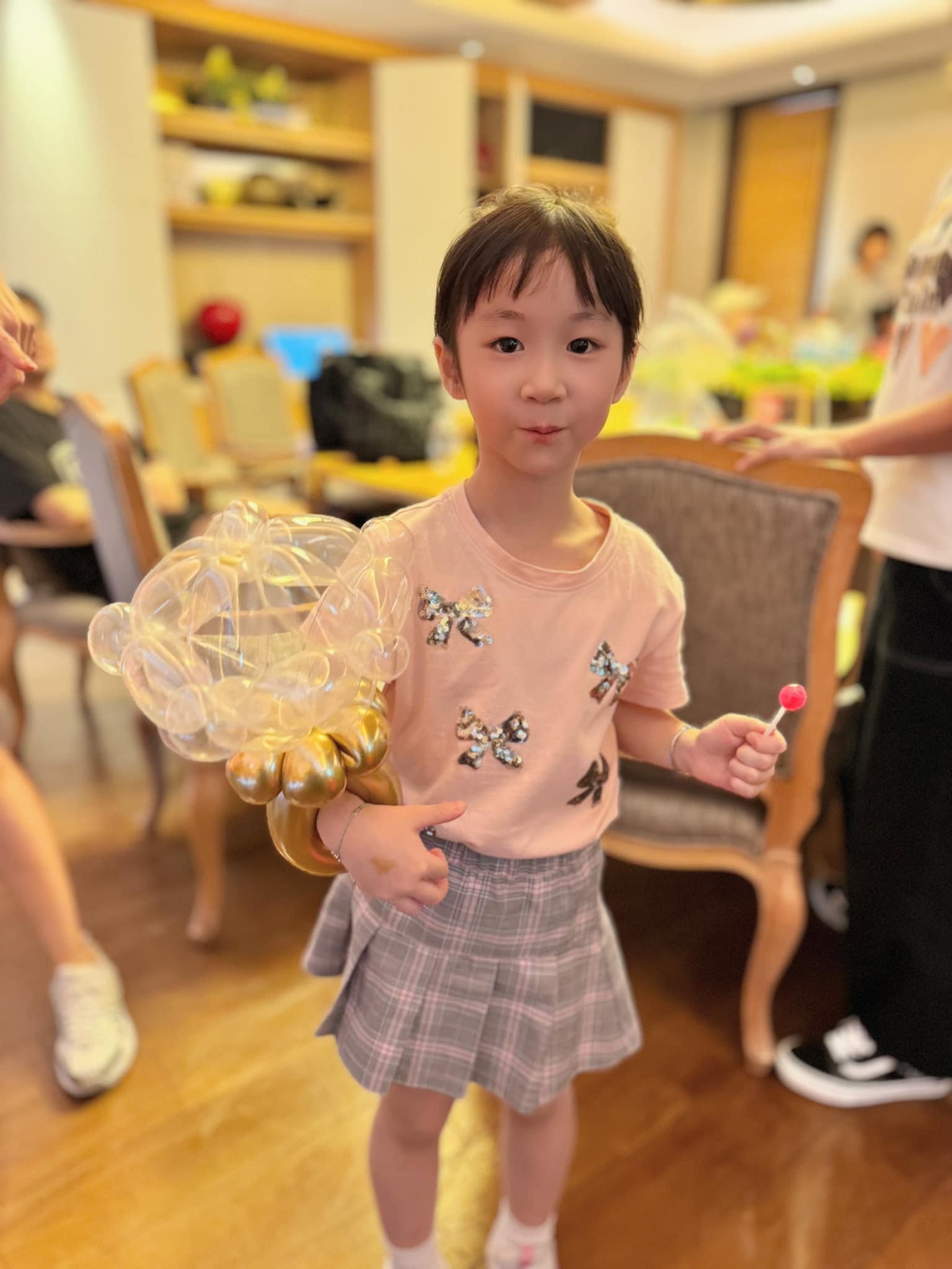 小女孩拿著透明泡泡氣球加金色底座的手環