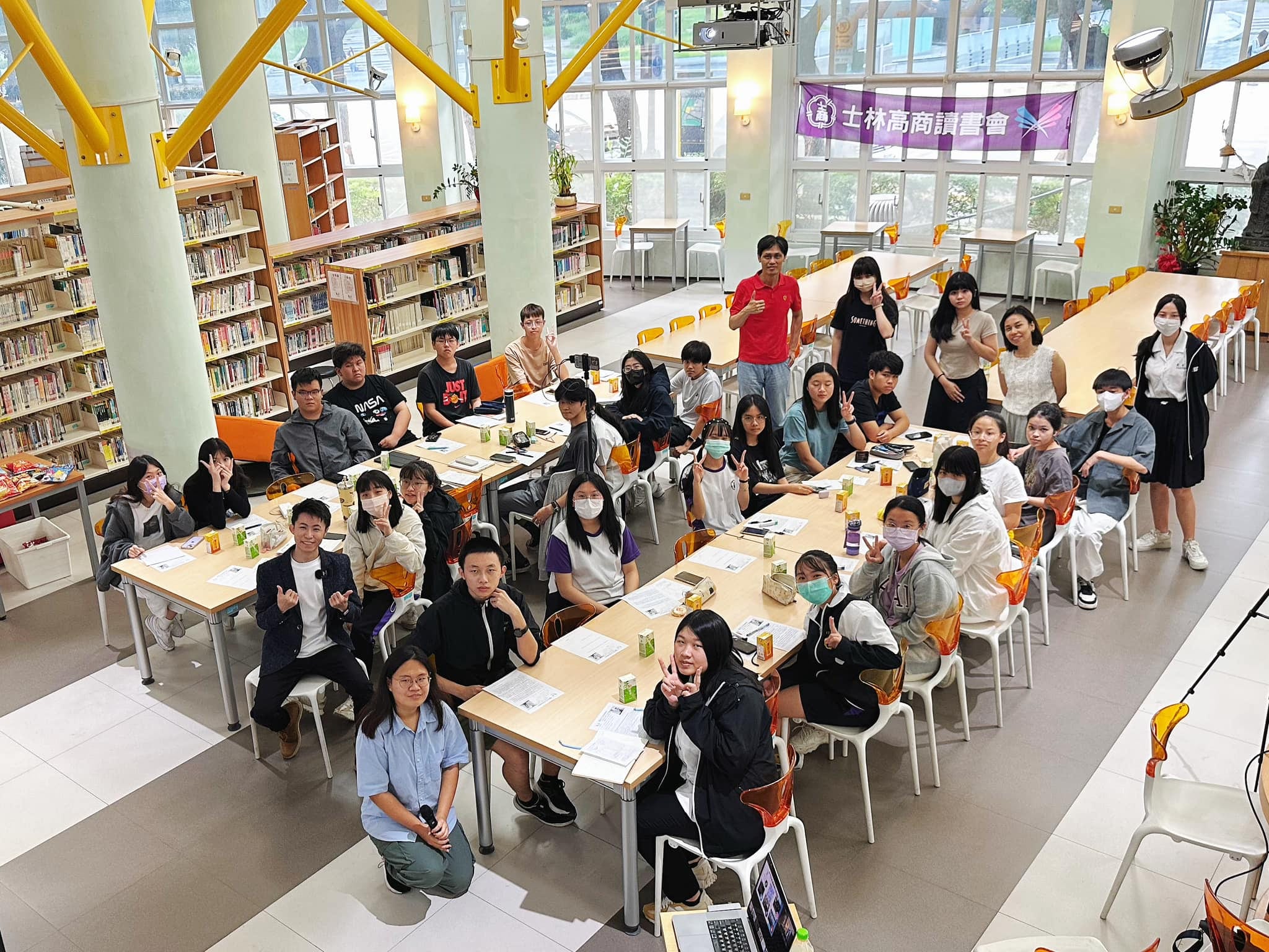 2024 年士林高商圖書館演講後，學生圍坐長桌合照