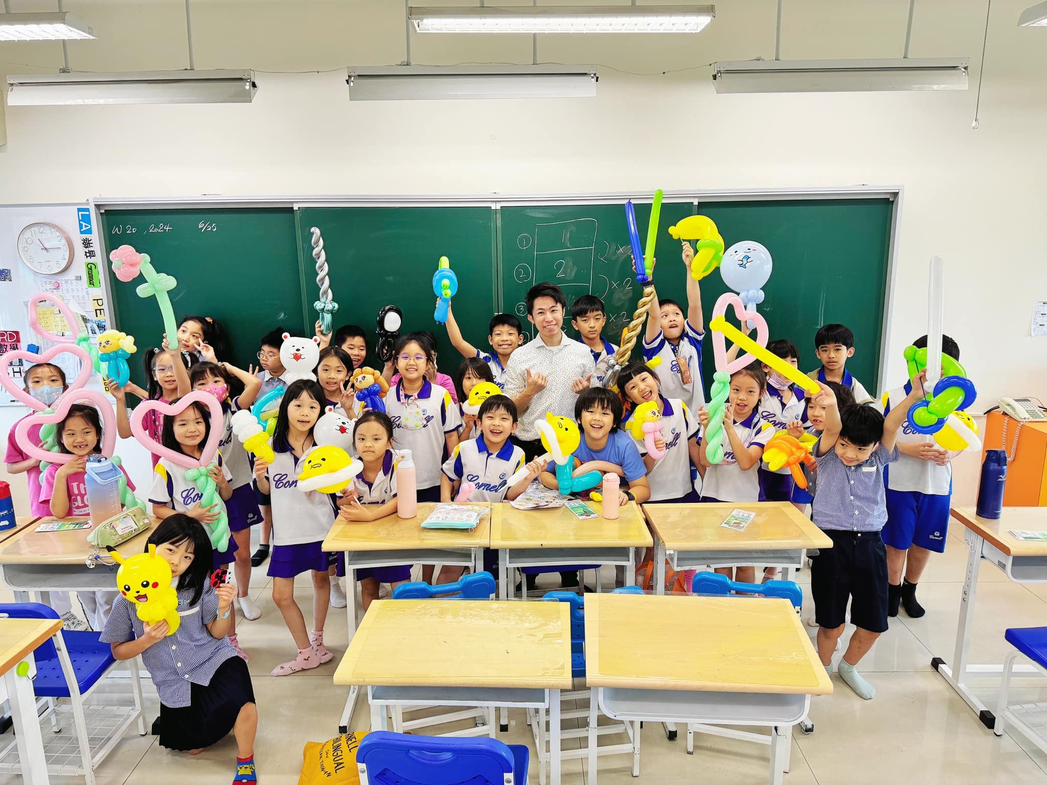 魔術社學生在黑板前擺姿勢，手上拿著皮卡丘、愛心、寶劍等造型氣球