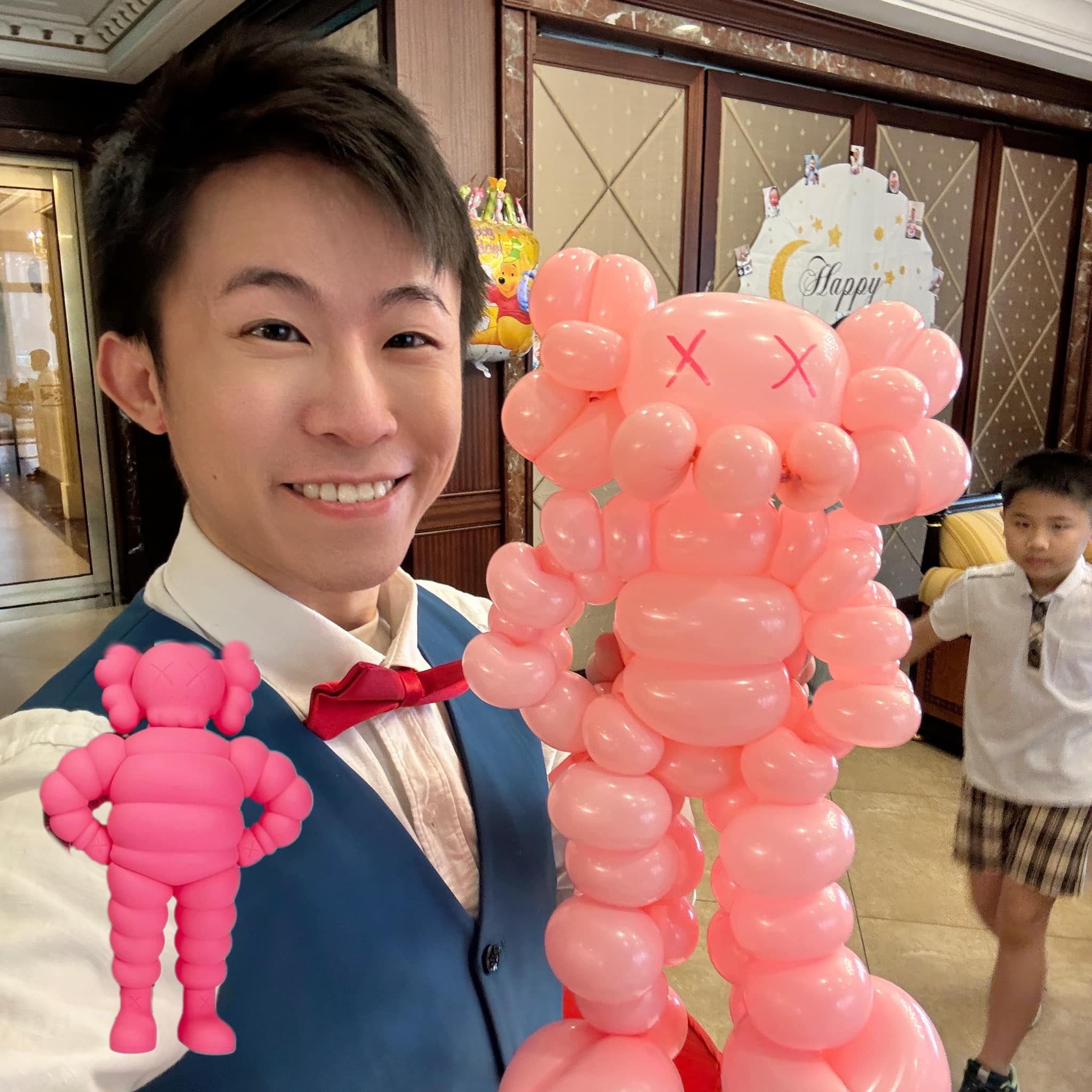 柯男自拍，旁邊是照著粉紅色 Kaws 公仔做的大型粉紅造型氣球