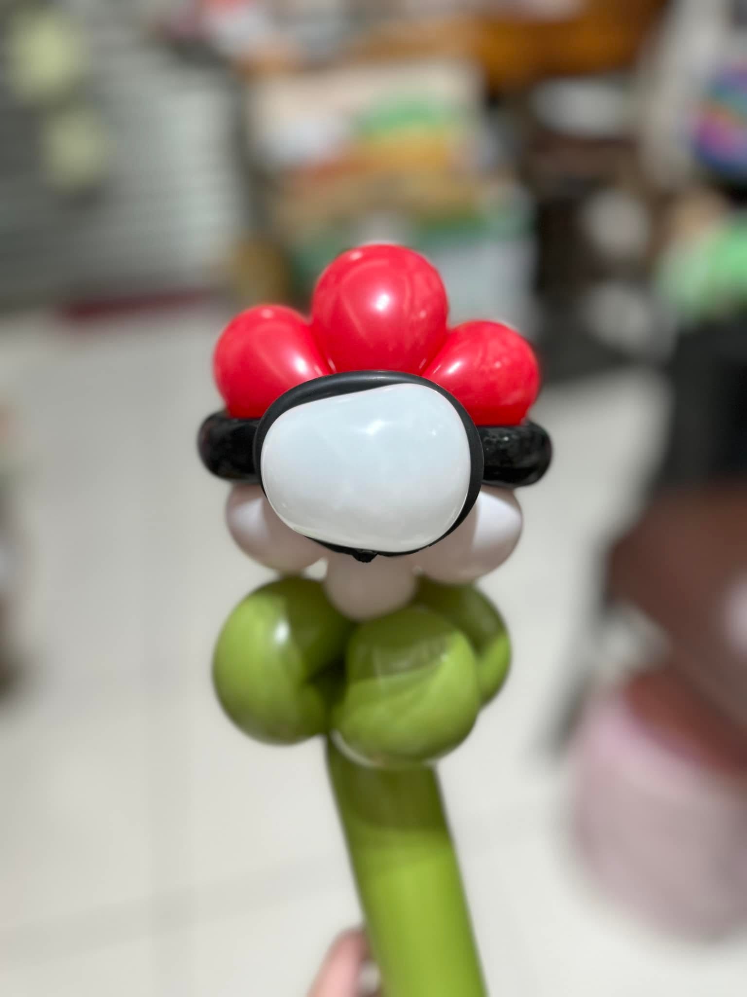 紅白配色的精靈球造型氣球花，中間有黑色帶子