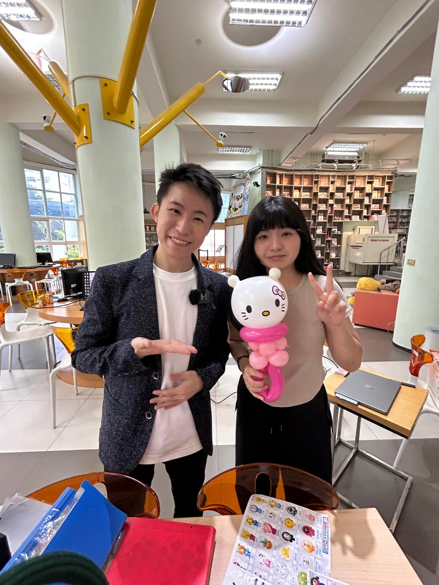 學生比 YA 拿著 Hello Kitty 造型氣球和柯男合照