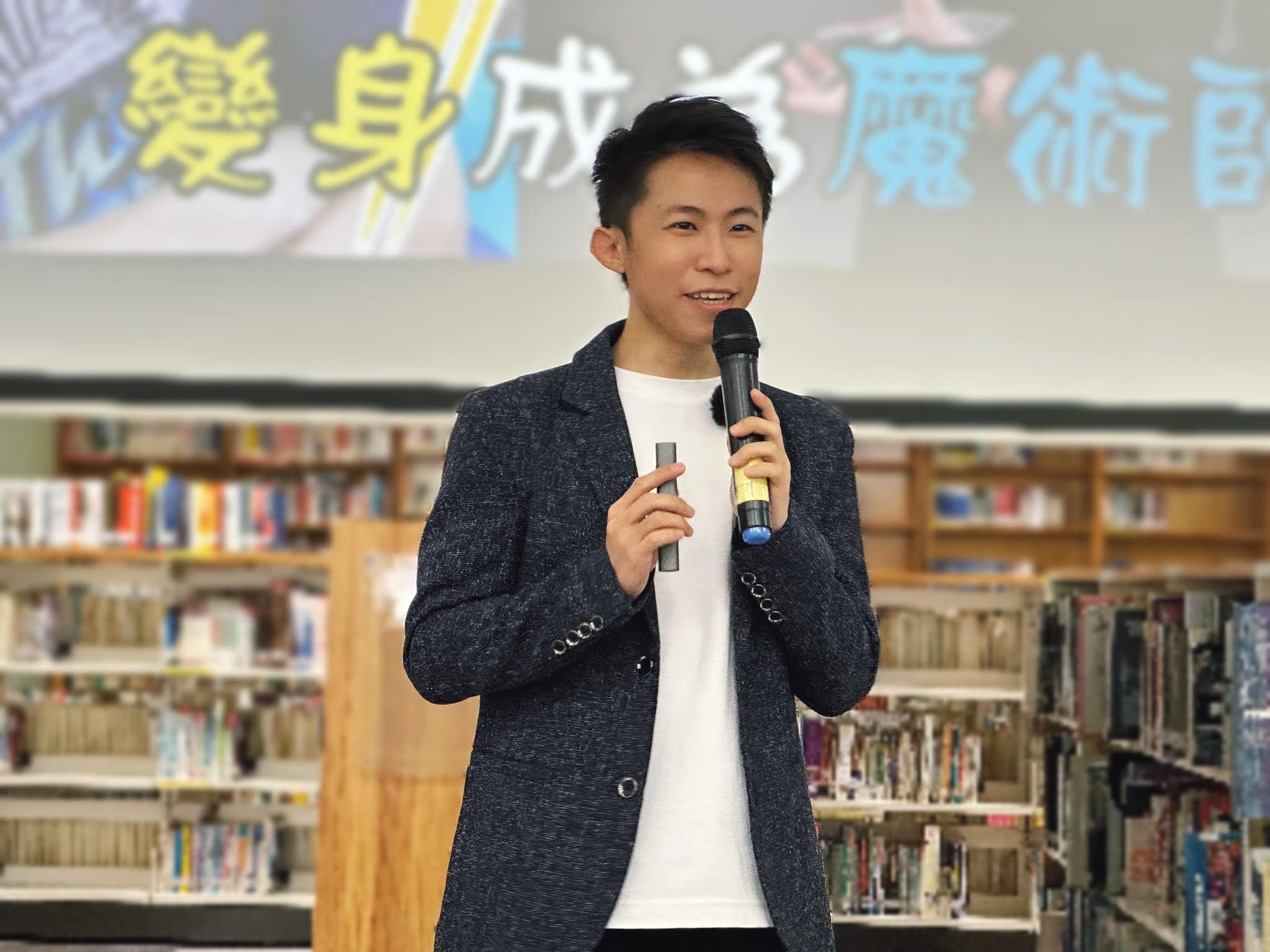 柯男拿著麥克風演講，背後投影寫著變身成為魔術師