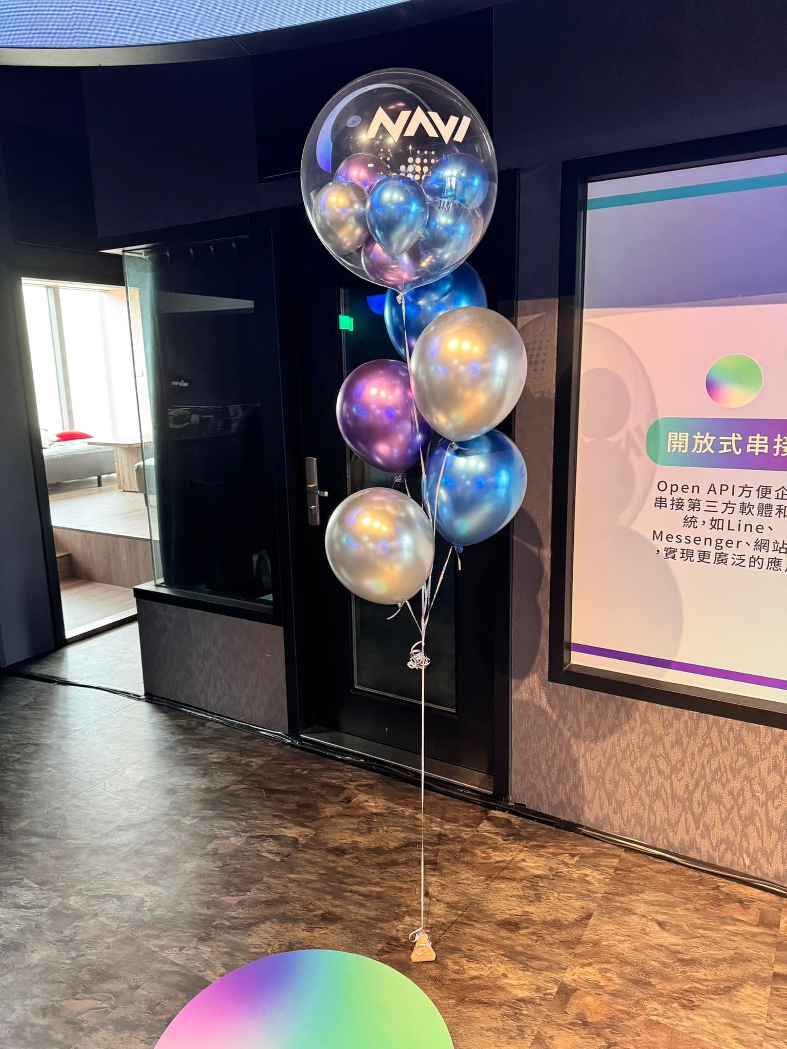 門邊的氣球束，頂端是貼 LOGO 的波波球，下方是銀、紫、藍金屬氣球