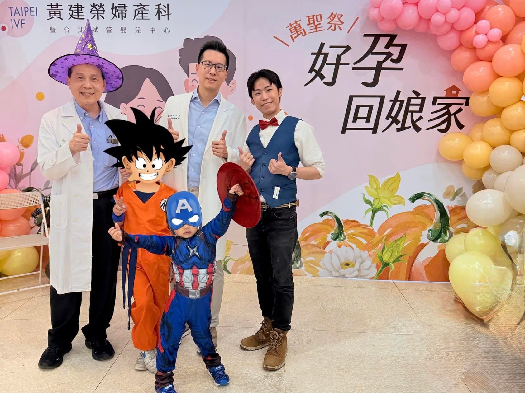 穿孫悟空與美國隊長裝扮的小朋友，和戴巫師帽的醫師在萬聖節背板前合照
