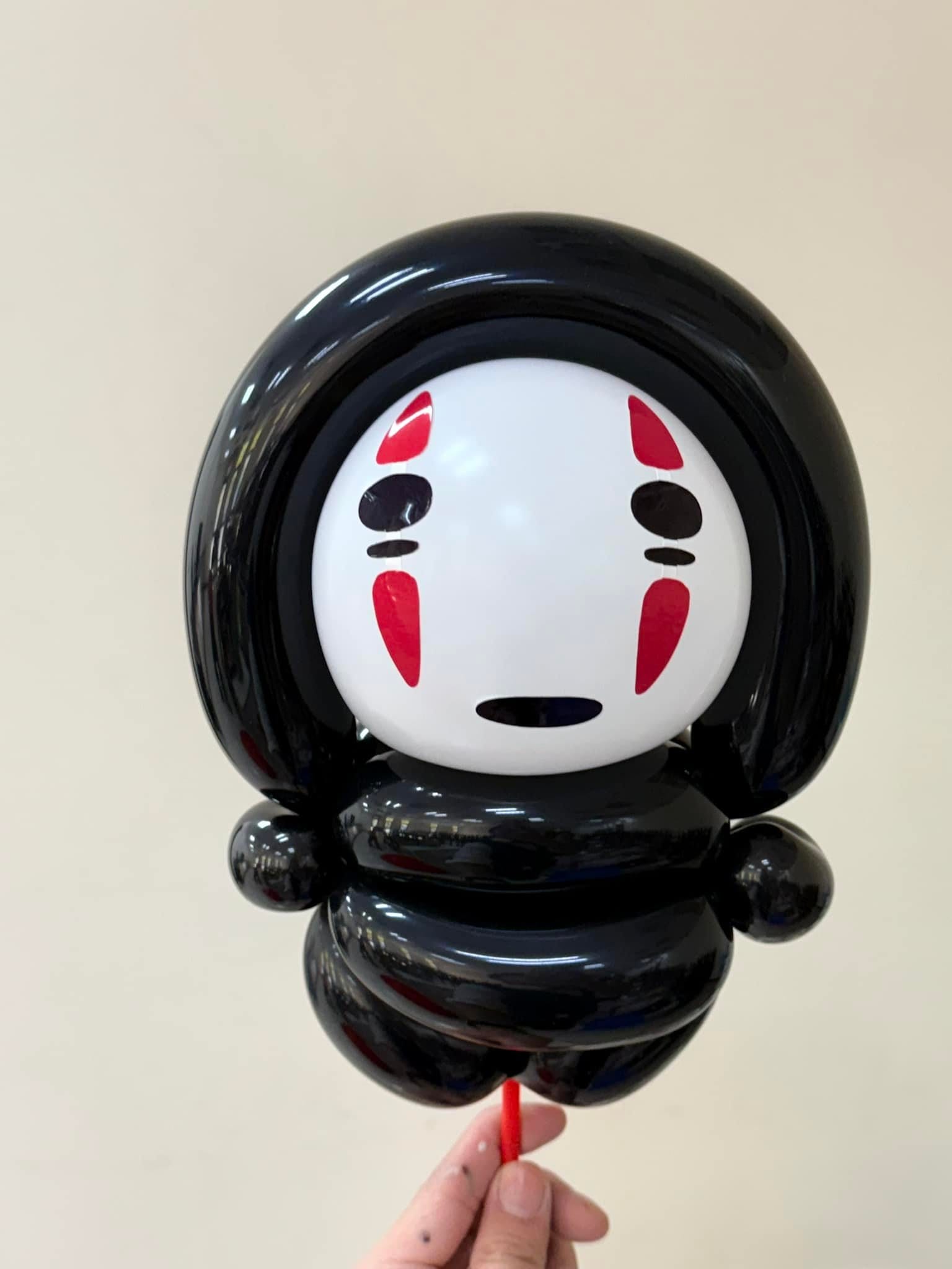 黑色身體、白色面具畫著紅色紋路的無臉男造型氣球