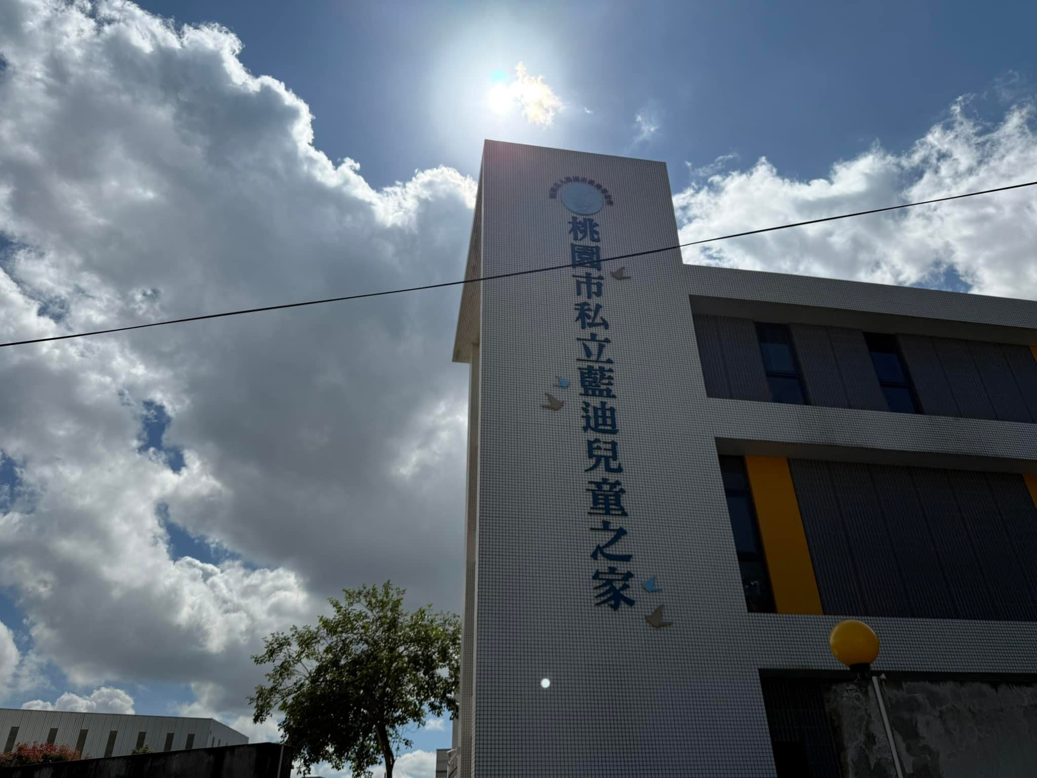 桃園市私立藍迪兒童之家的外牆招牌，藍天白雲下的白色建築