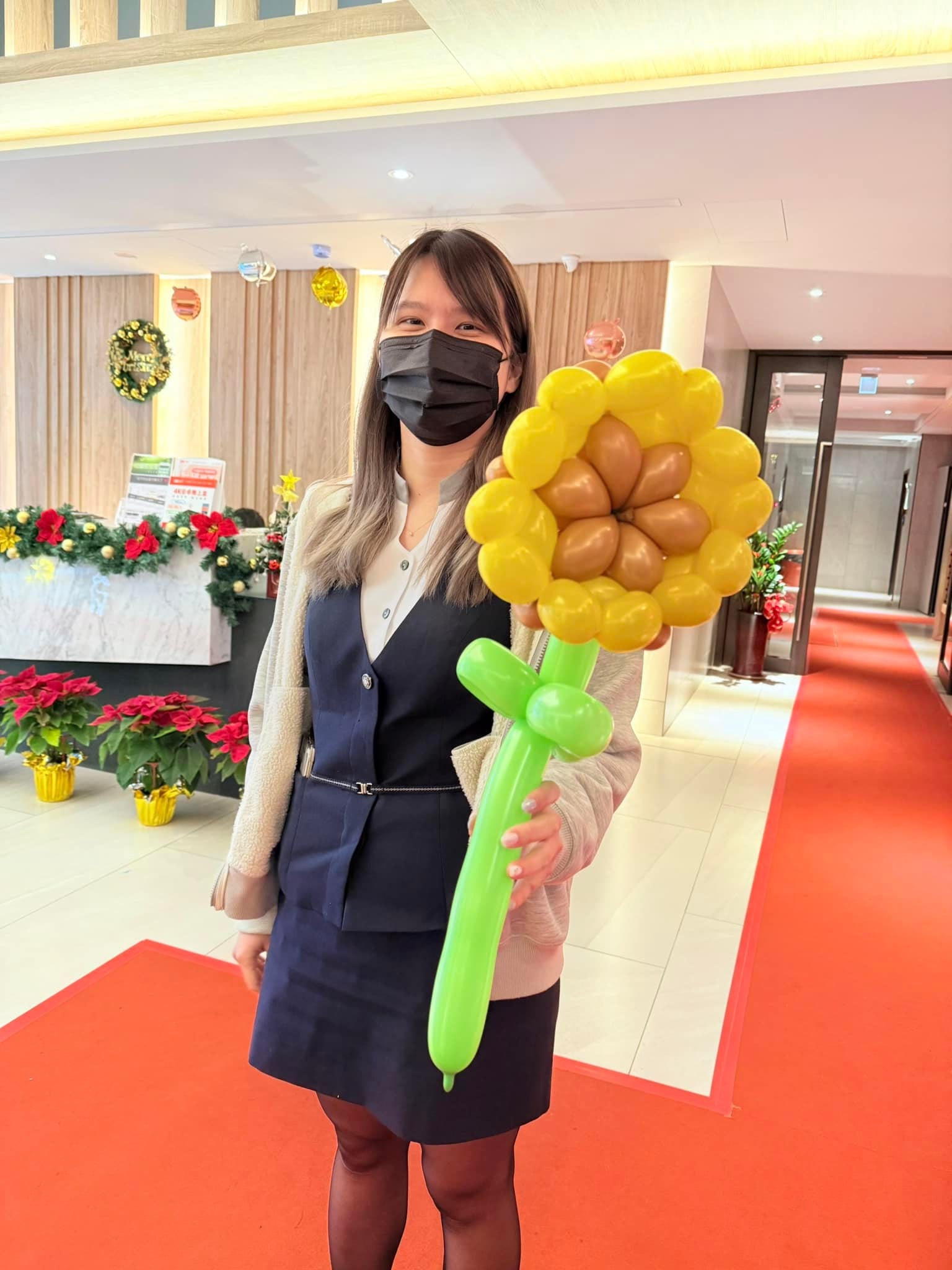 後續週六：建案大廳裡女士拿著向日葵造型氣球