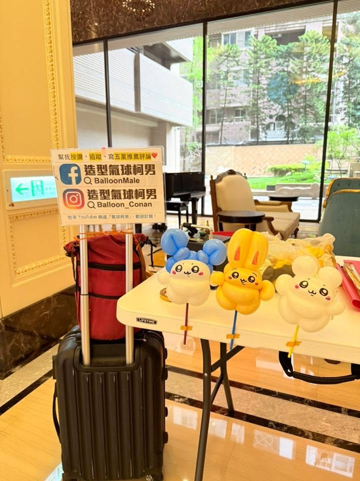 大廳折氣球那場：桌上插著角色造型氣球棒的攤位