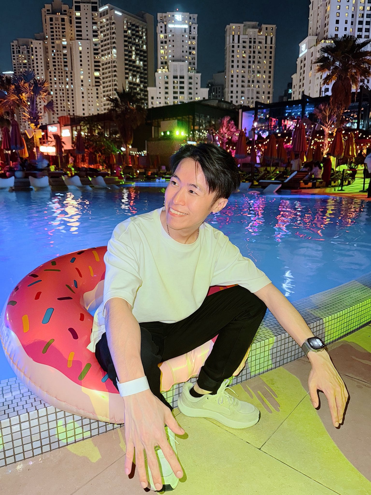 夜晚的泳池邊,我蹲在甜甜圈造型泳圈旁