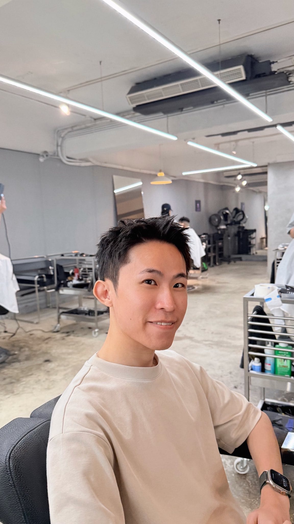 我坐在髮廊座椅上，展示剪短後的新髮型