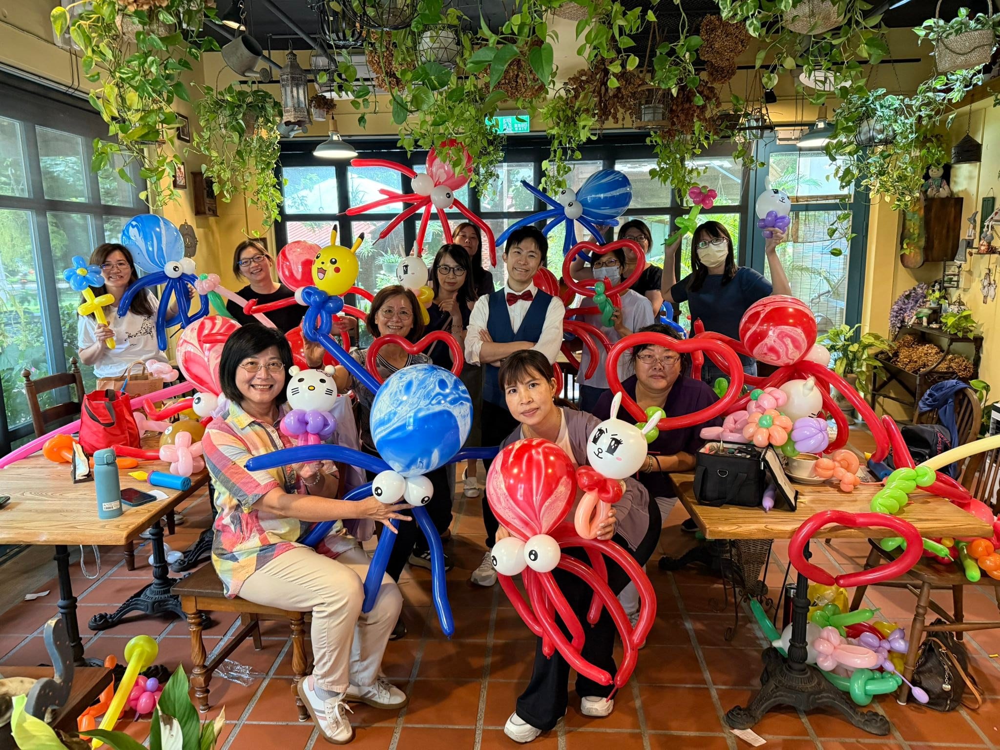 志工氣球教學課程結束後，學員抱著紅色、藍色大章魚與愛心氣球和柯男合照