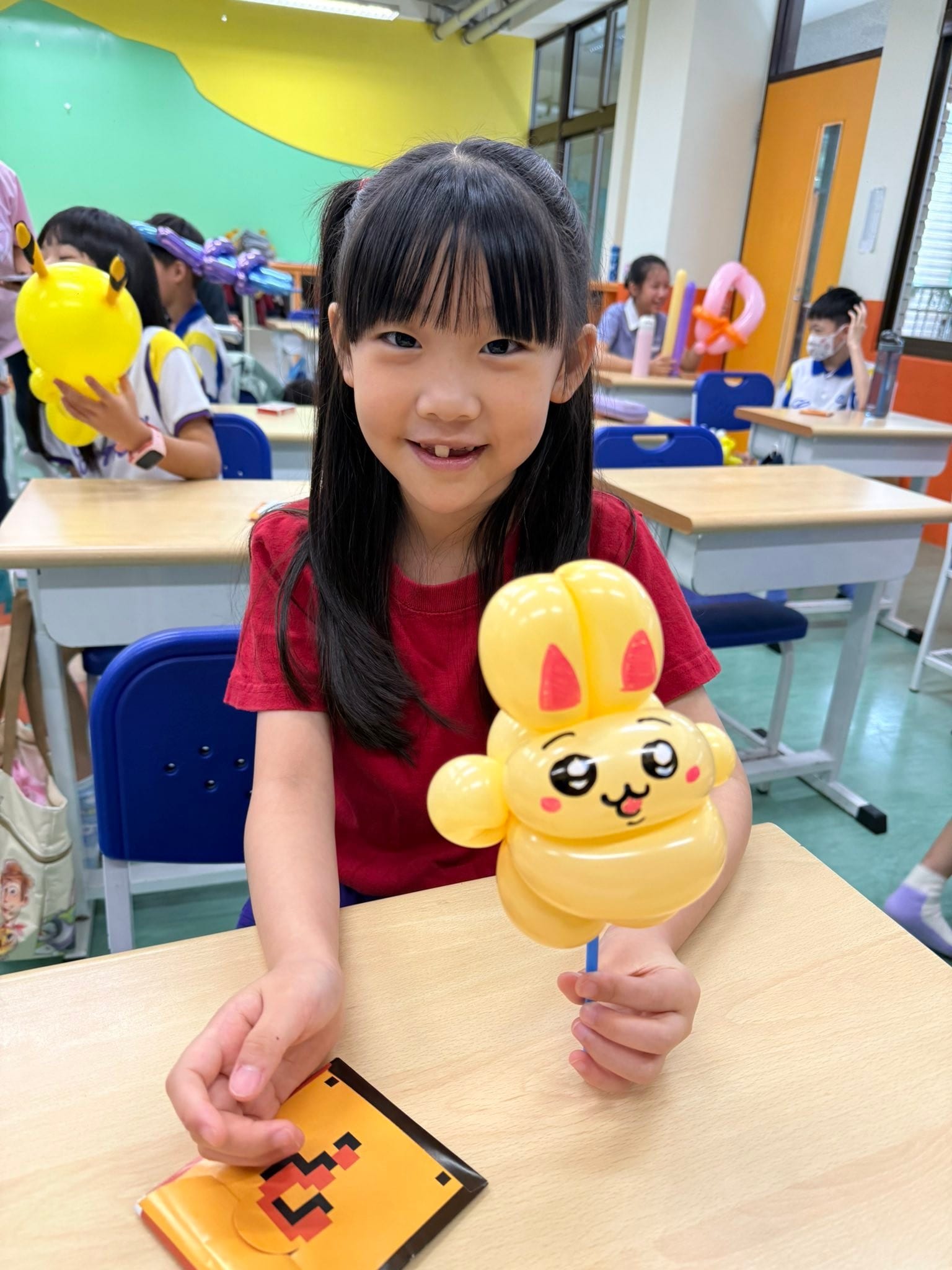 缺了門牙的女孩笑著拿起吉伊卡哇系列烏薩奇造型氣球棒