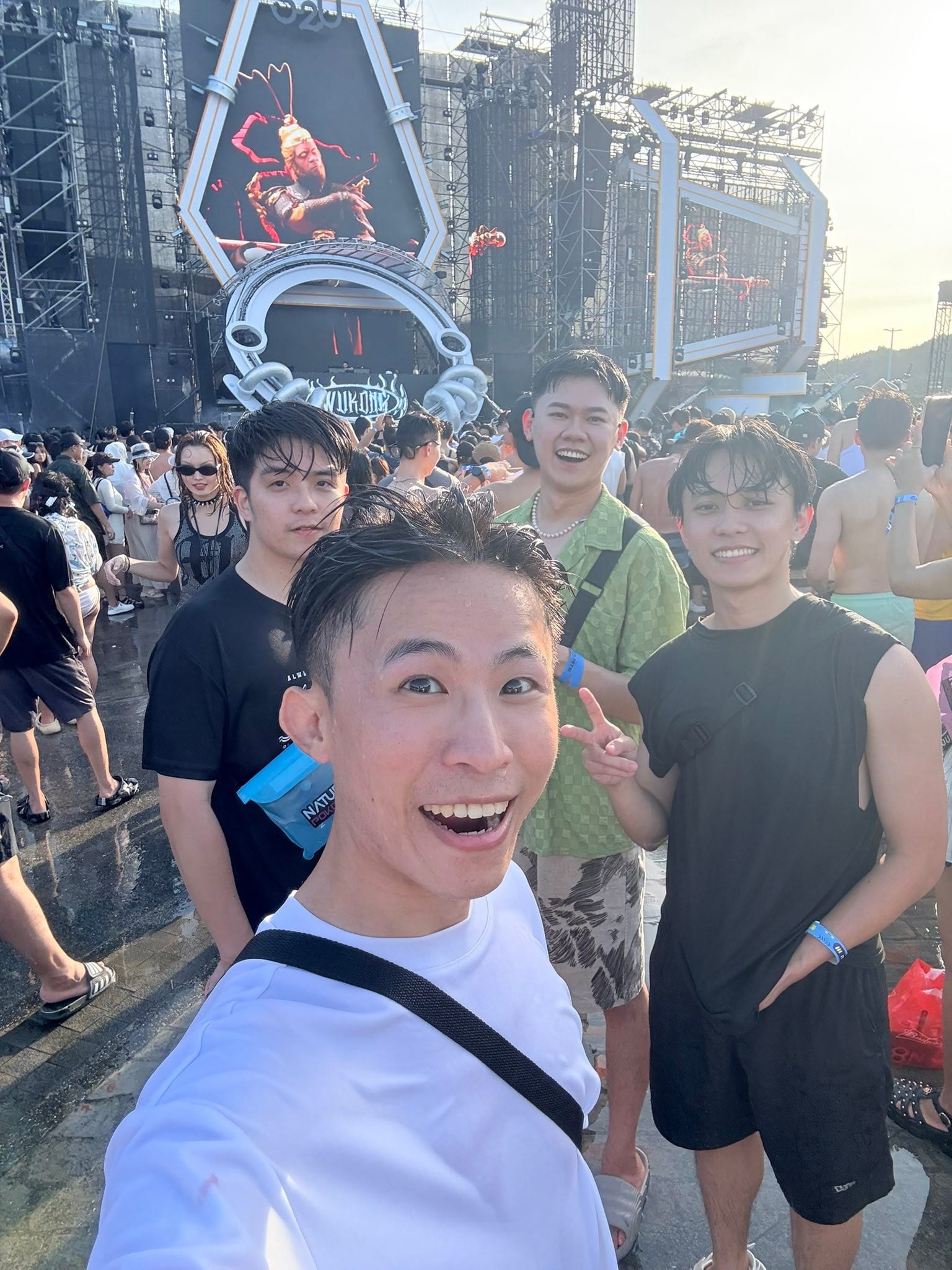 我和朋友在電音派對主舞台前自拍，後方是巨大的舞台裝置
