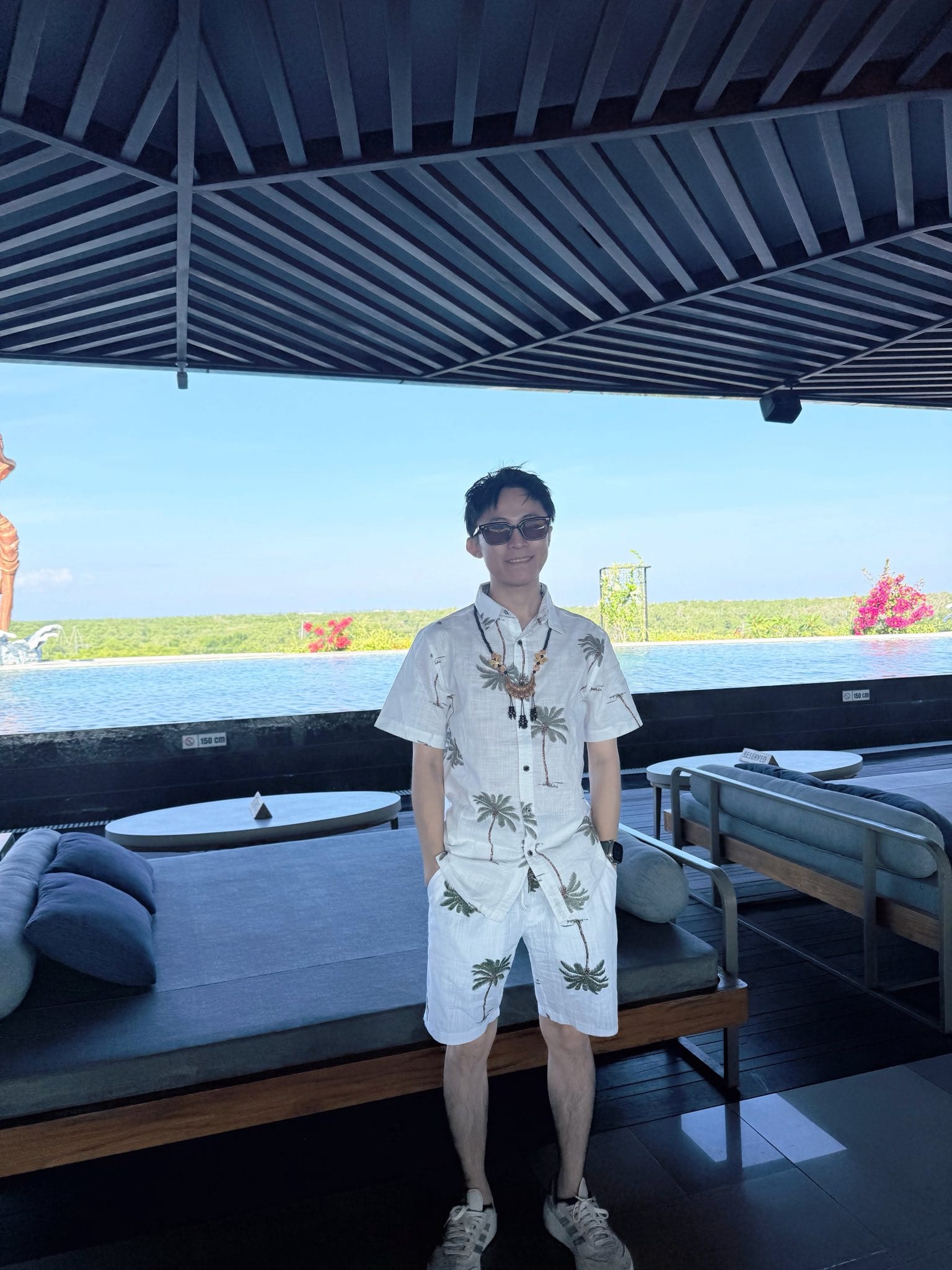 我穿著當地風格的白色花襯衫套裝，站在峇里島 villa 的泳池邊