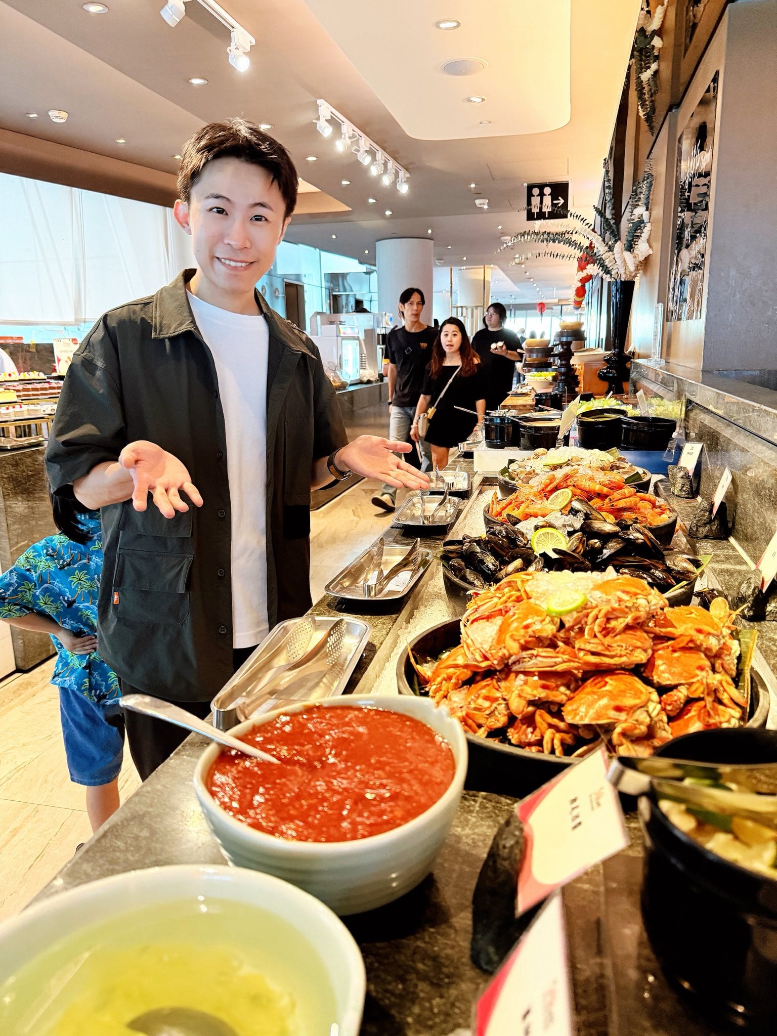 我站在自助餐檯前，桌上擺滿螃蟹與各種料理