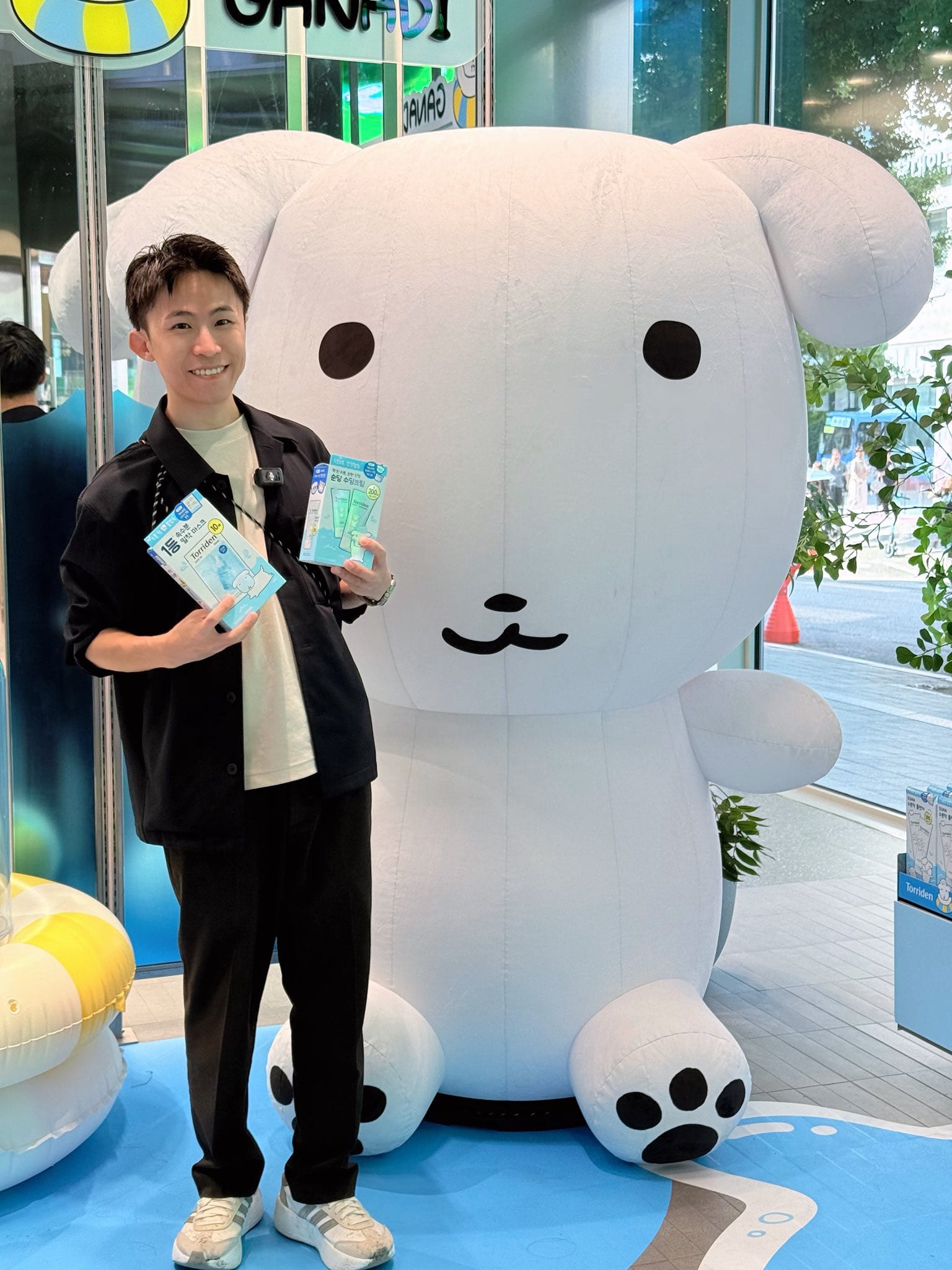 我拿著小卡站在巨大的白色小狗人偶旁