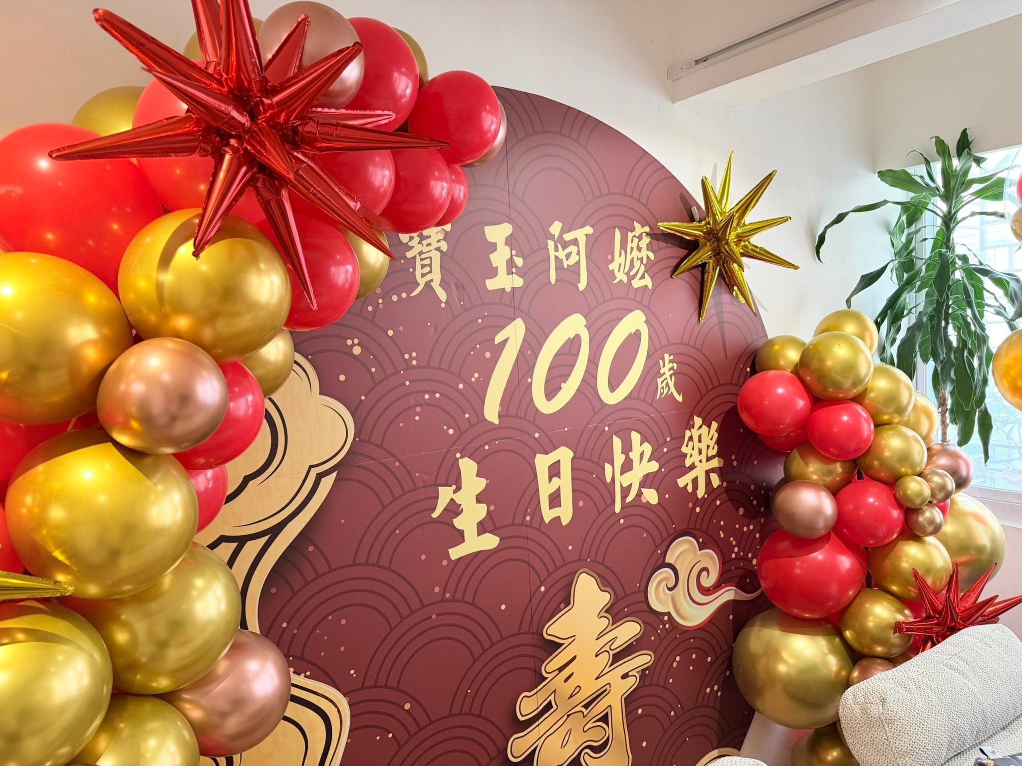 壽宴背板特寫，紅色與金色爆炸星鋁箔氣球點綴在紅金氣球串上