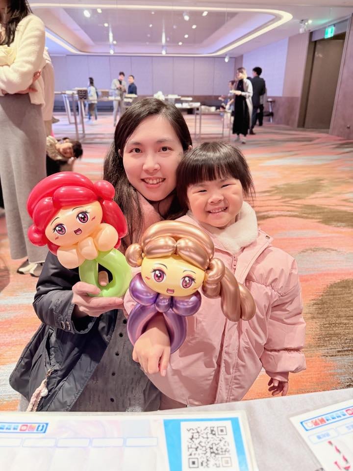 1 月另一場婚禮：媽媽和女兒各拿小美人魚（紅髮綠尾巴）與長髮公主（金髮紫衣）造型氣球