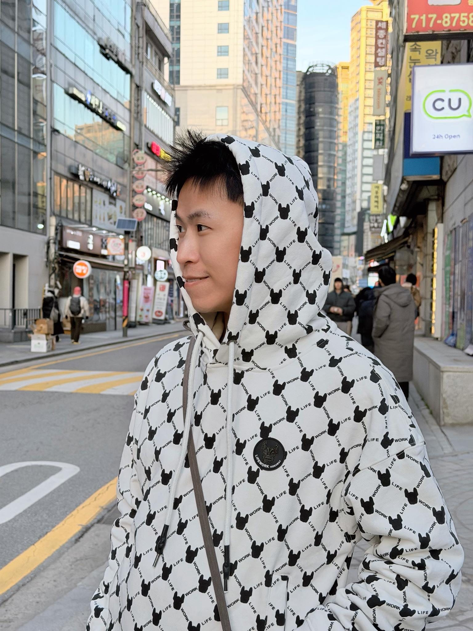 我戴著黑白圖案連帽外套，站在首爾弘大街頭