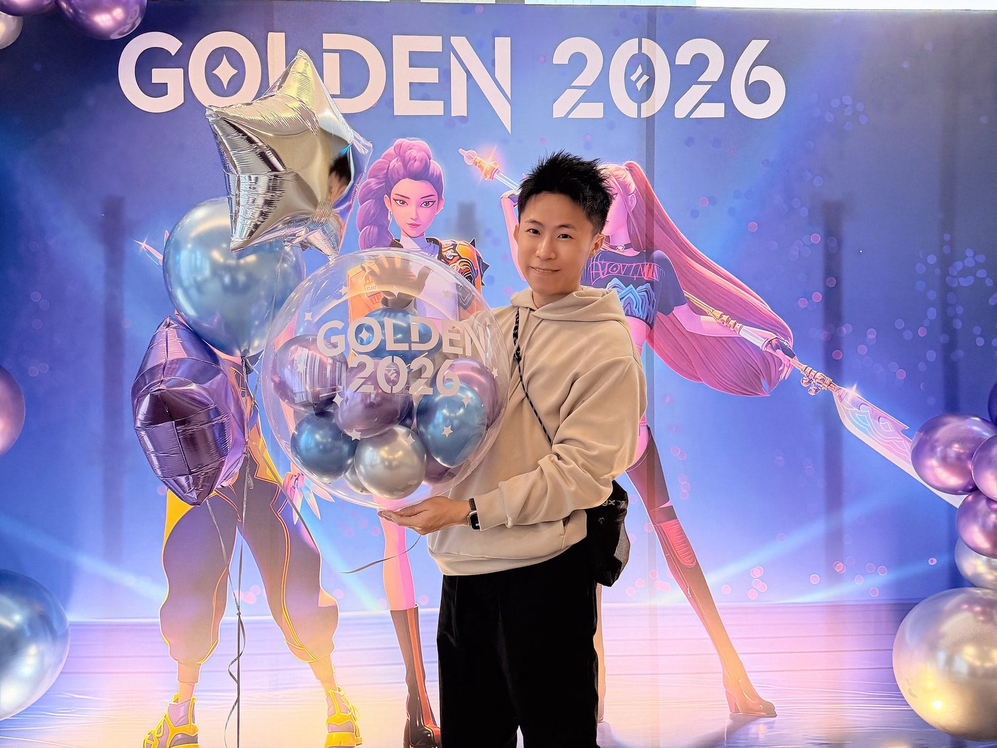 12 月另一場：柯男抱著 GOLDEN 2026 透明波波球站在背板前