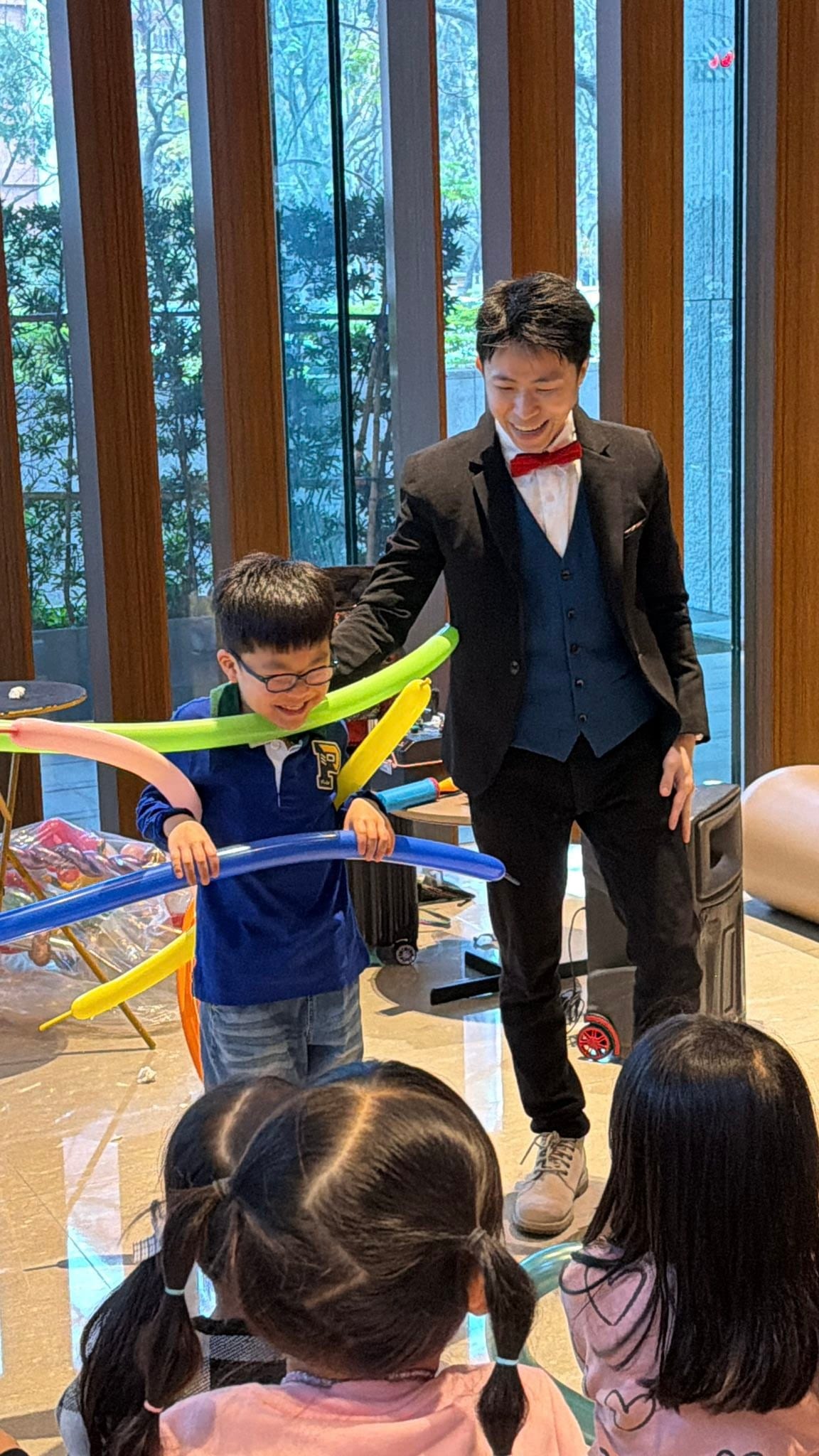 1 月生日派對：魔術表演中男孩拿著長條氣球圈協助