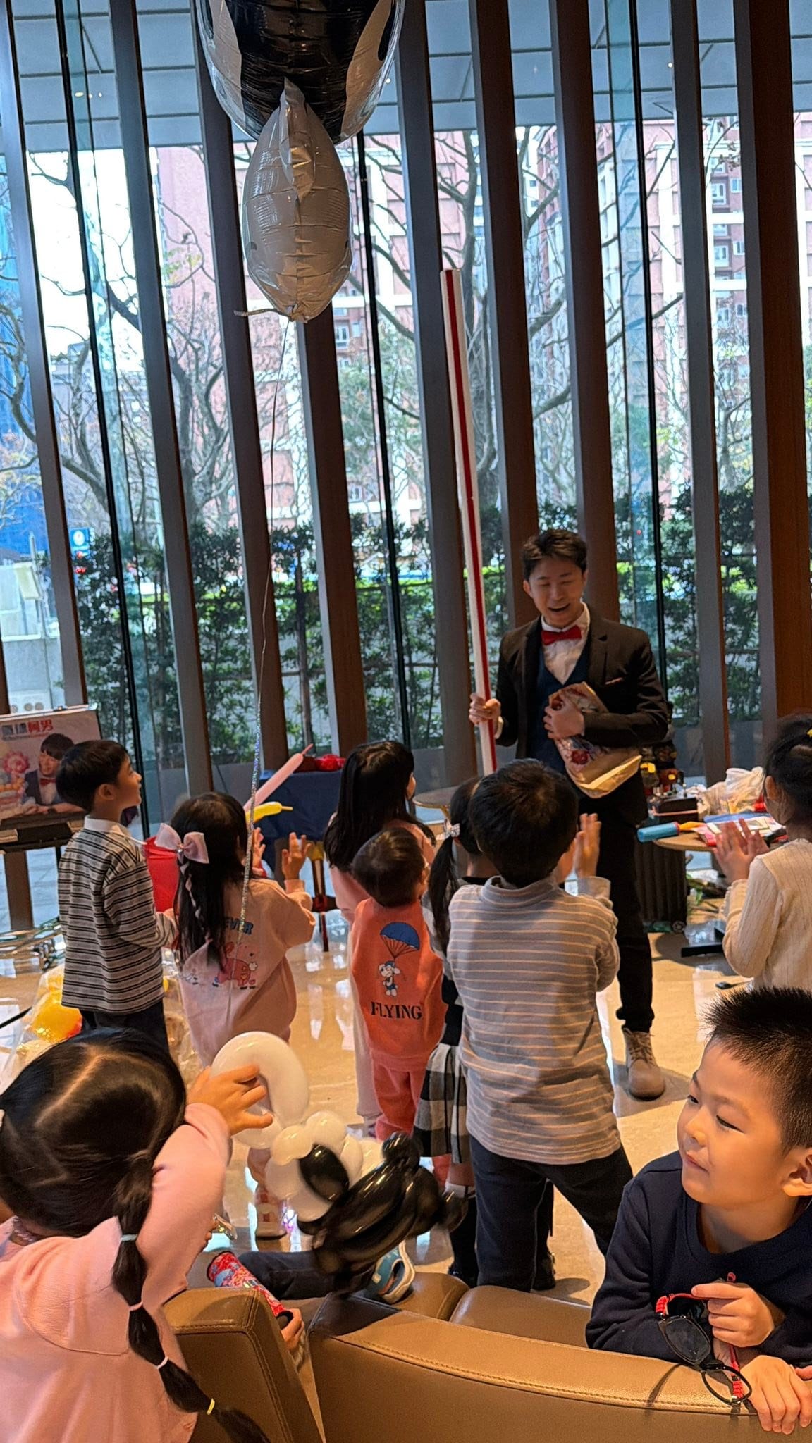 1 月生日派對：柯男拿紅色魔術帽表演，三個女孩專心看