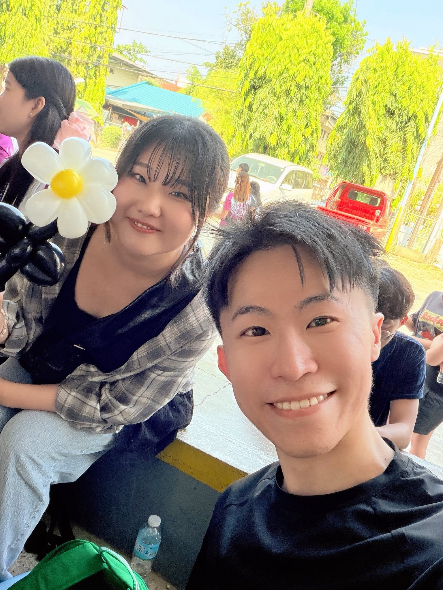 同學拿著白色小雛菊造型氣球花和我自拍