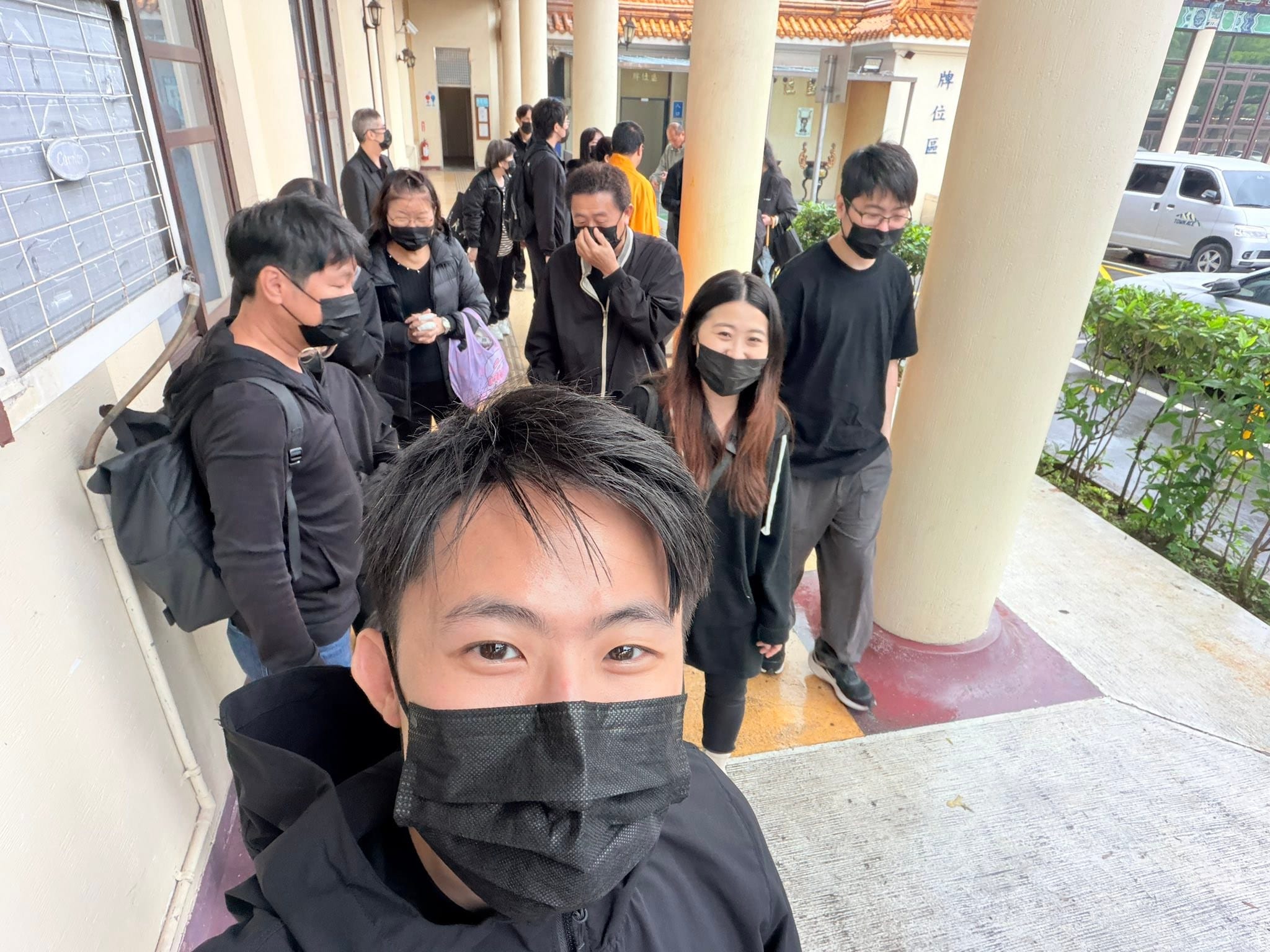 送外婆最後一程那天，我戴黑色口罩和穿黑衣的家人在走廊上